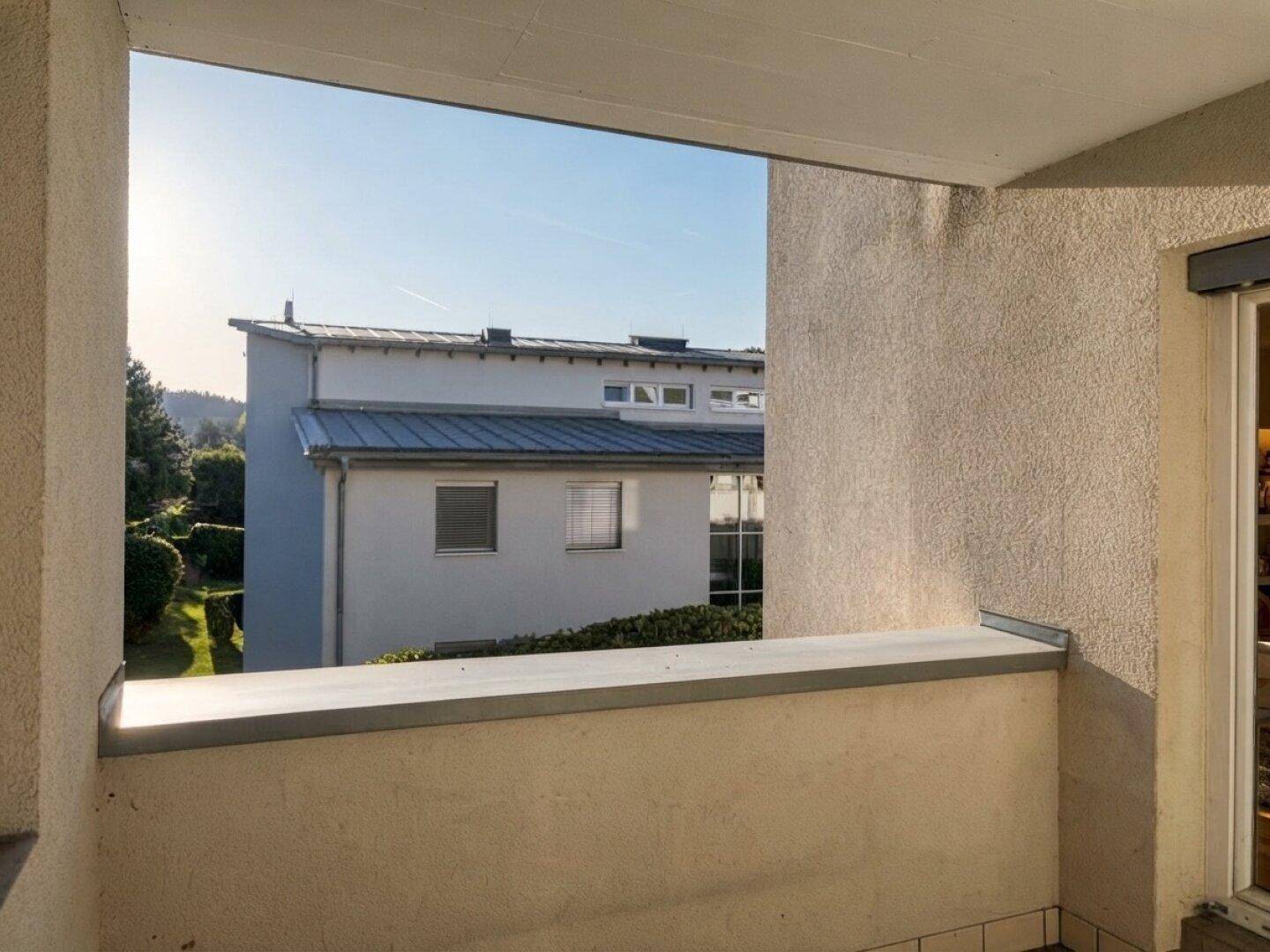 Balkon mit Blick auf die umliegenden Gebäude und grüne Umgebung.