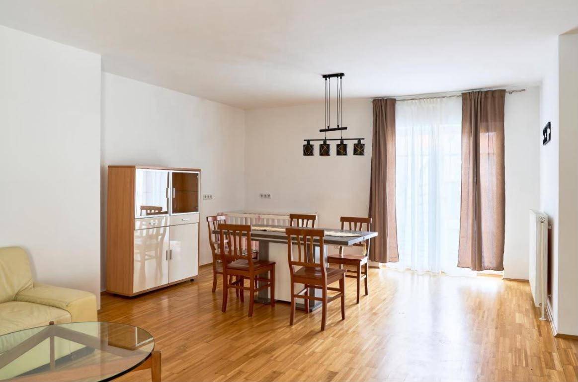 Essbereich mit Holztisch, Stühlen und großem Fenster, ideal für Familienmahlzeiten.