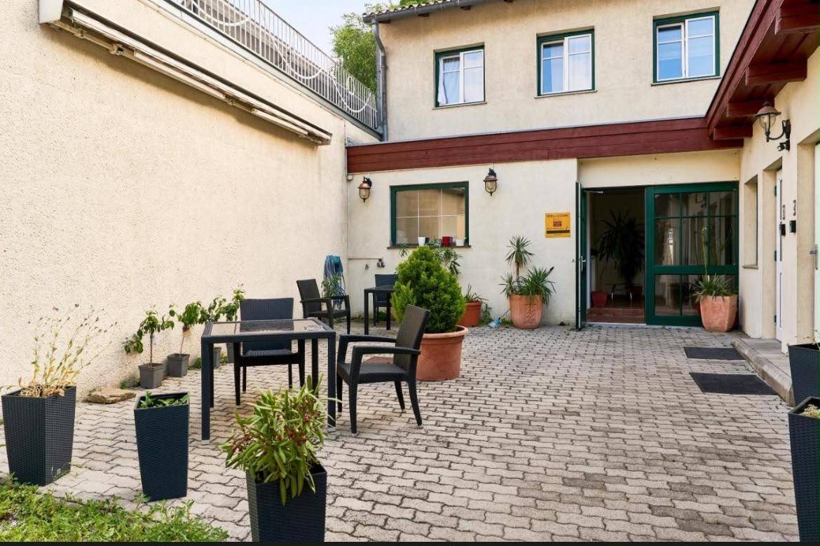 Gepflasterter Innenhof mit Sitzgelegenheiten und Pflanzen, perfekt für entspannte Stunden.