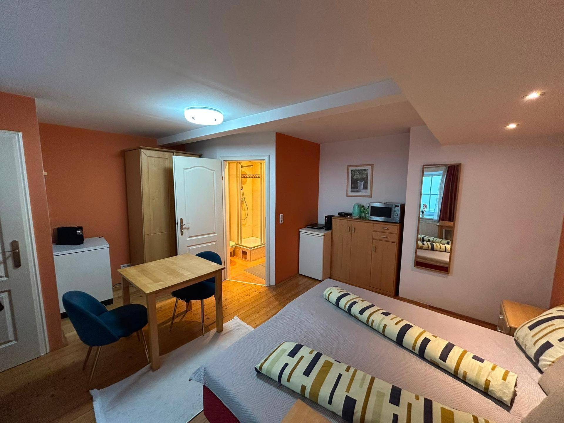 Geräumiges Studio-Apartment mit Doppelbett, Essbereich und Zugang zum Badezimmer.