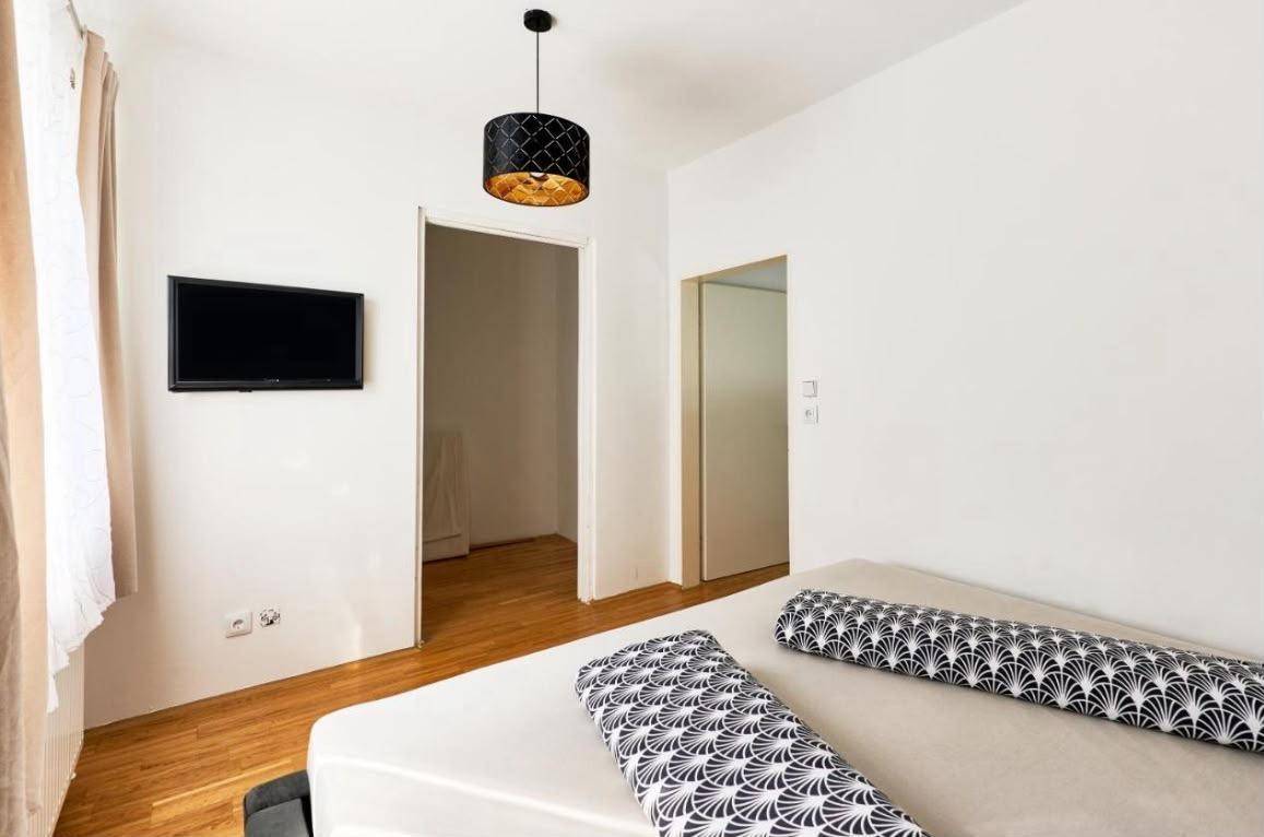 Helles Schlafzimmer mit Doppelbett und Holzboden in schlichtem, modernem Stil.