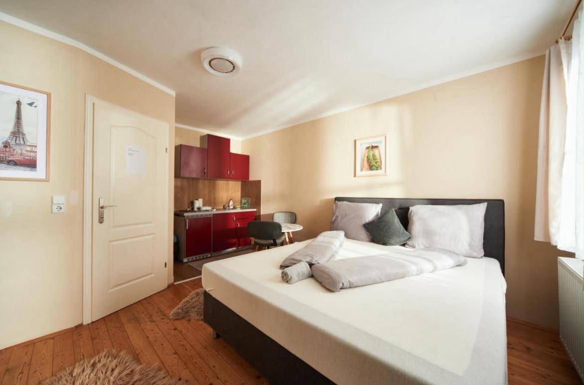 Helles Studio-Apartment mit Doppelbett, Küchenzeile und Holzboden.