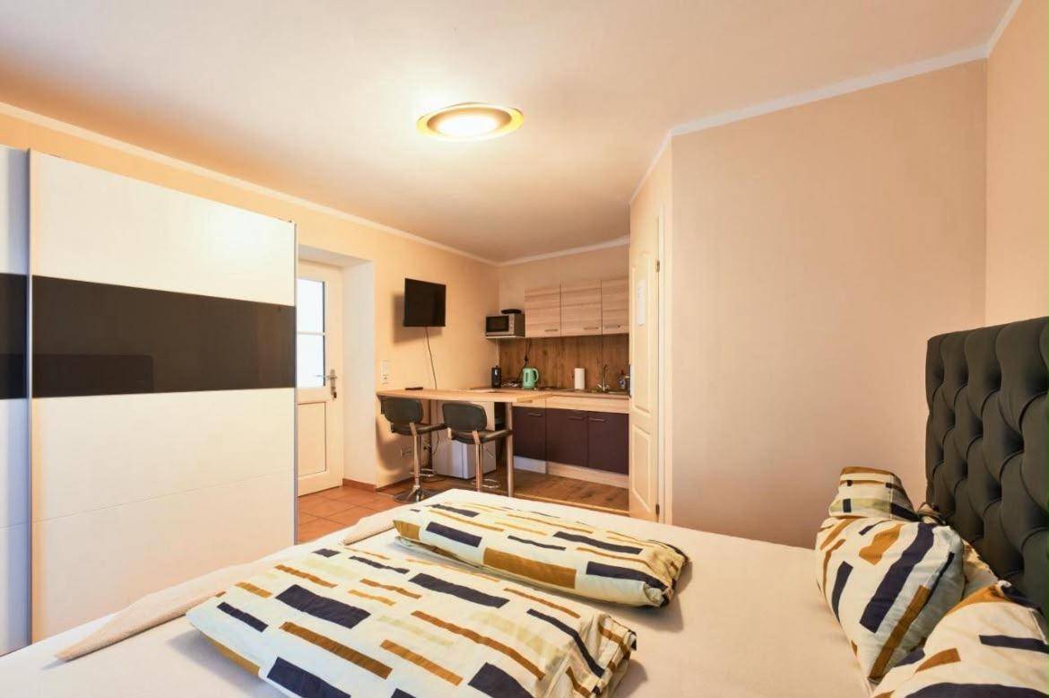 Schlafzimmer mit Doppelbett und Blick auf die integrierte Küchenzeile und den Essbereich.