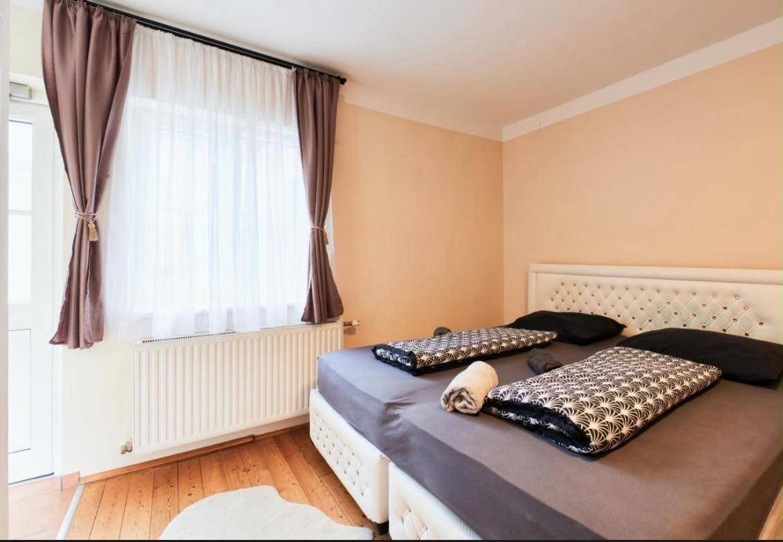 Helles Schlafzimmer mit Doppelbett, Kleiderschrank und Zugang zu einem Außenbereich.
