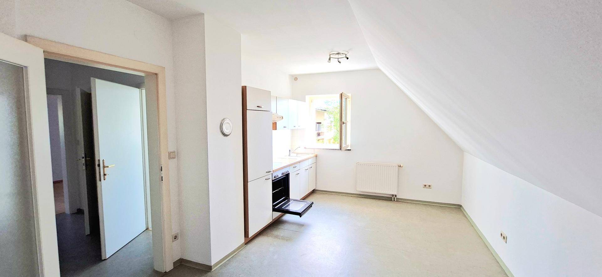 Kleine Küche in einem Dachgeschossraum mit einfacher Ausstattung und Fenster.