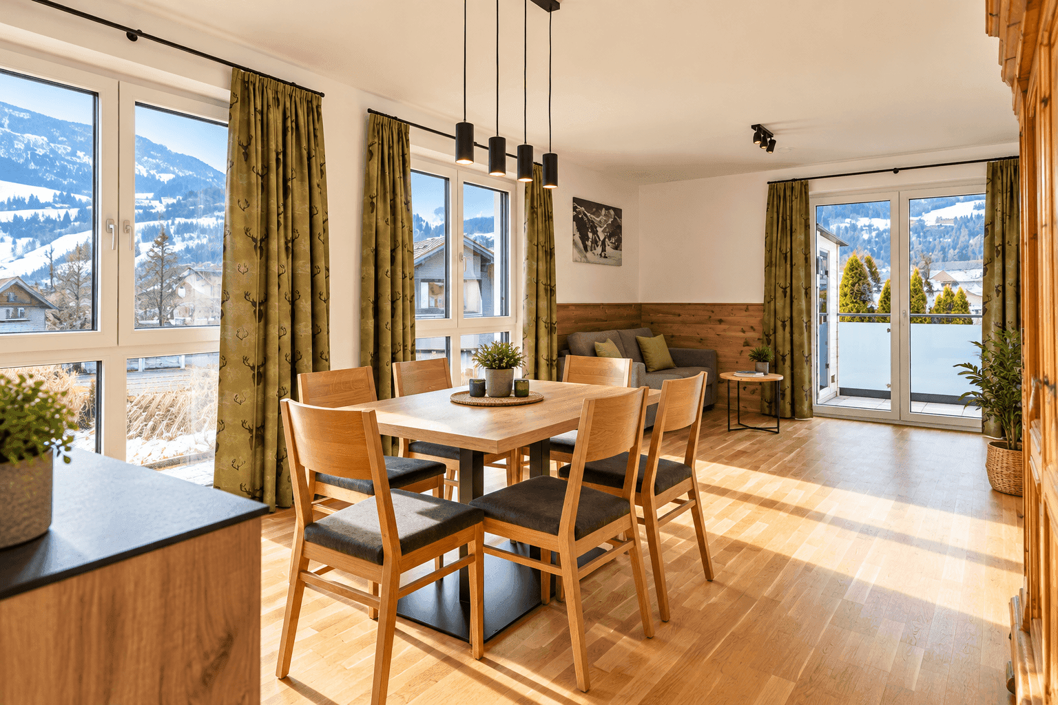 Heller Wohn-Essbereich mit Bergblick, Holzboden und Zugang zum Balkon.