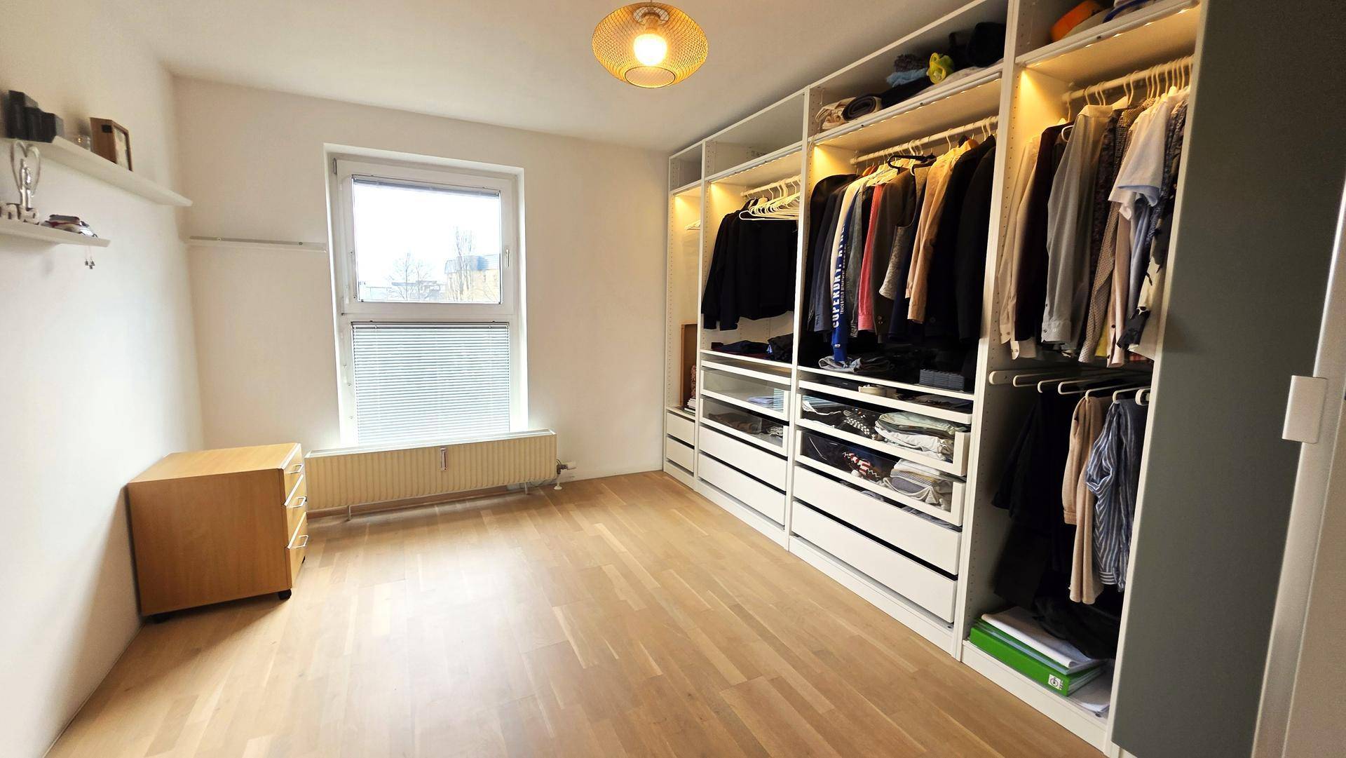 Helles Zimmer mit Einbauschränken und Holzboden, ideal als Ankleidezimmer oder Gästezimmer.