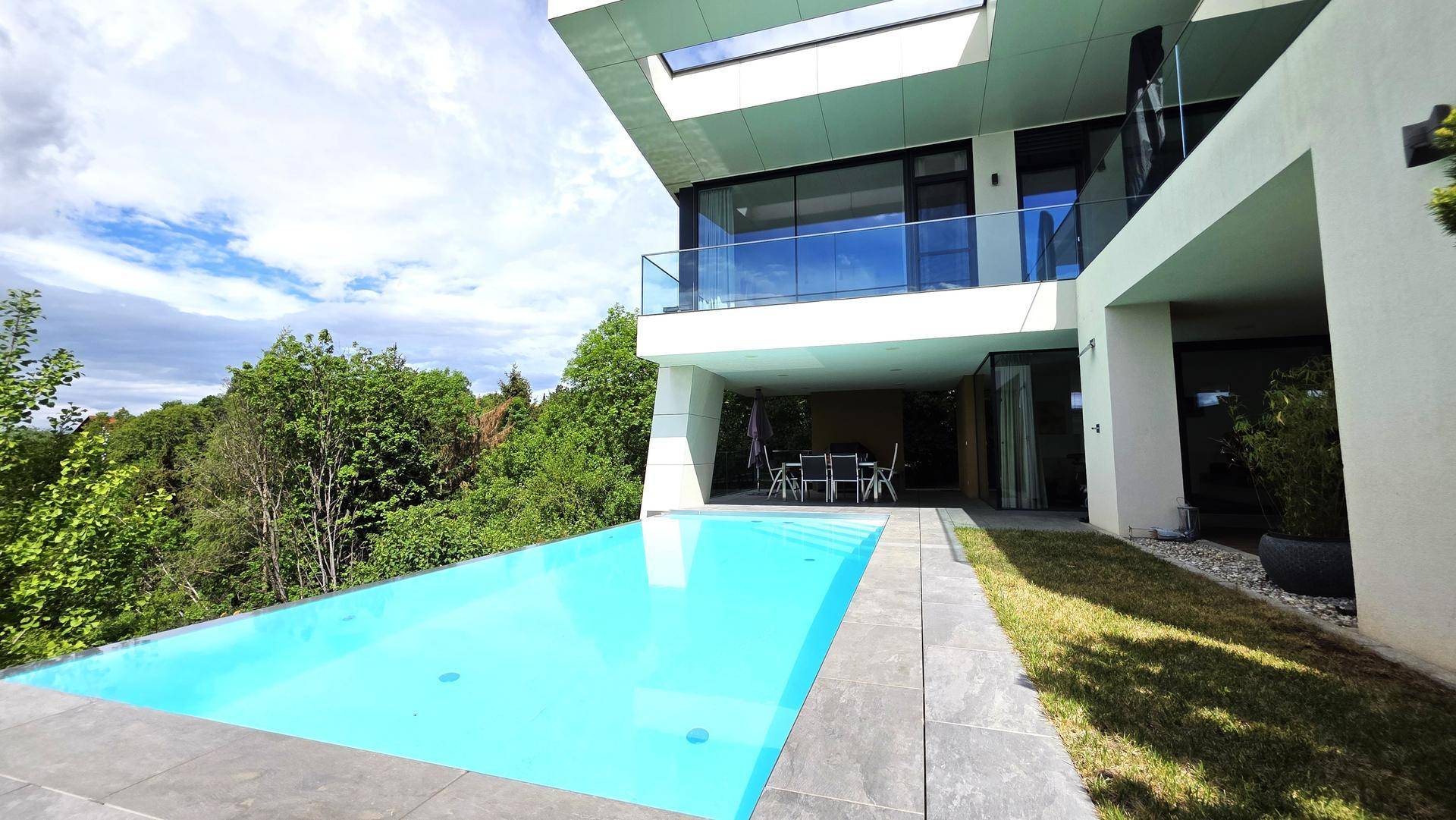 Erfrischender Poolbereich mit weitem Blick ins Grüne und moderner Architektur.