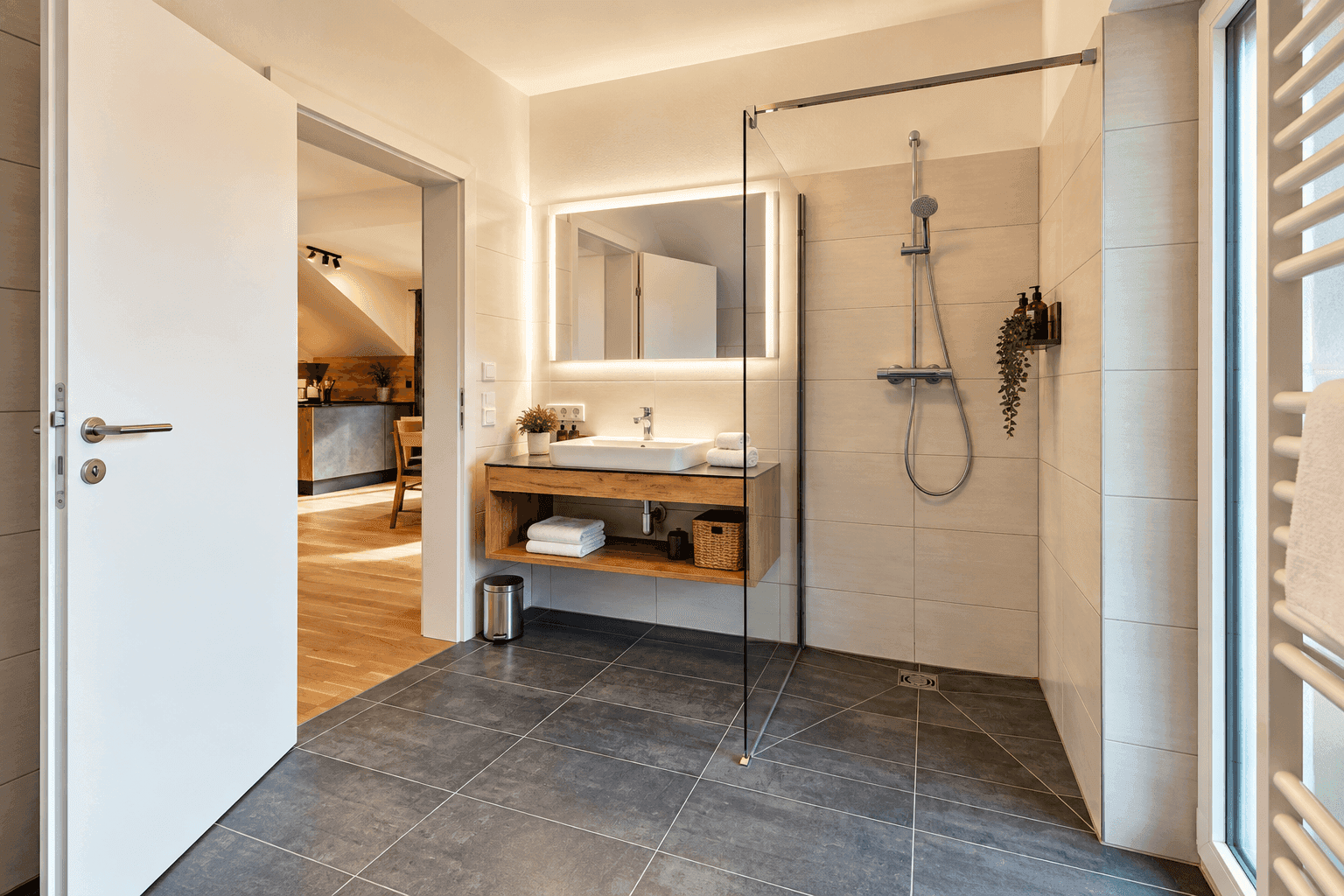 Helles Badezimmer mit ebenerdiger Dusche, Waschtisch und beheiztem Handtuchhalter.