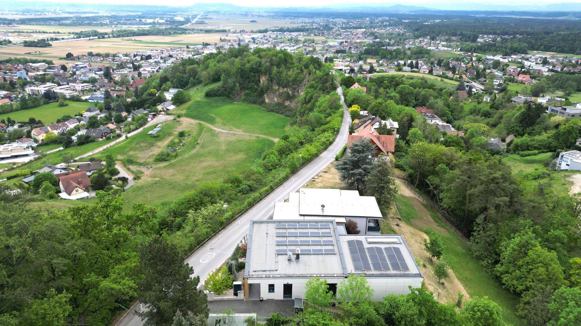 Panoramablick aus der Vogelperspektive auf die moderne Villa und die umliegende grüne Landschaft.