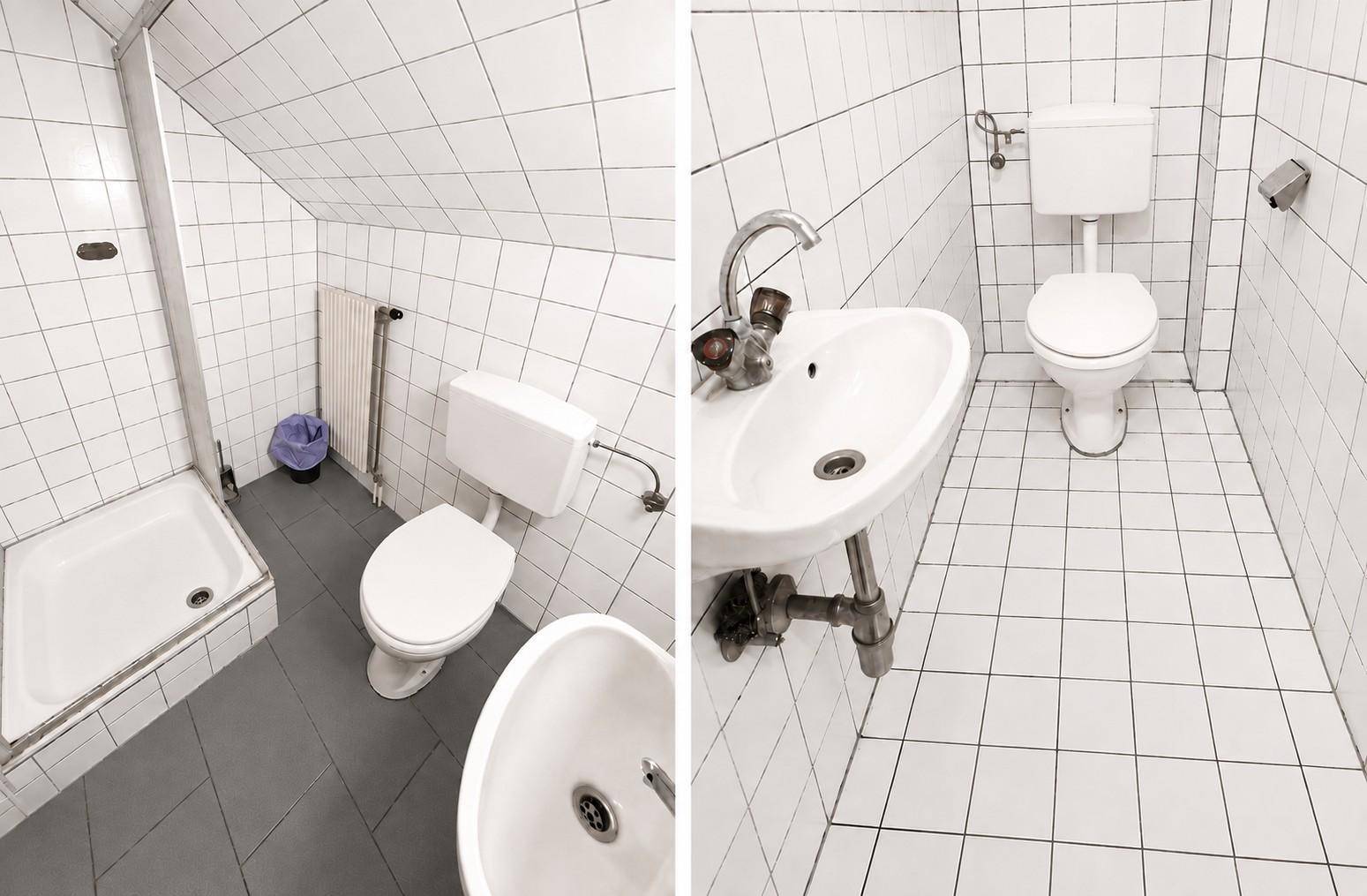 Kleines Badezimmer mit Dusche, WC und Waschbecken, komplett gefliest in Weiß.
