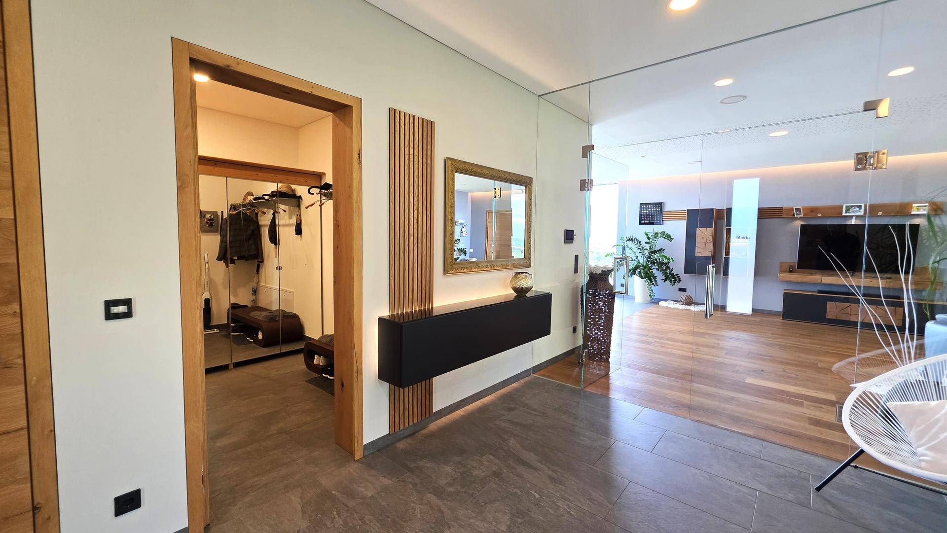 Moderner Flur mit Holztüren, Spiegelflächen und Zugang zu einem begehbaren Kleiderschrank.
