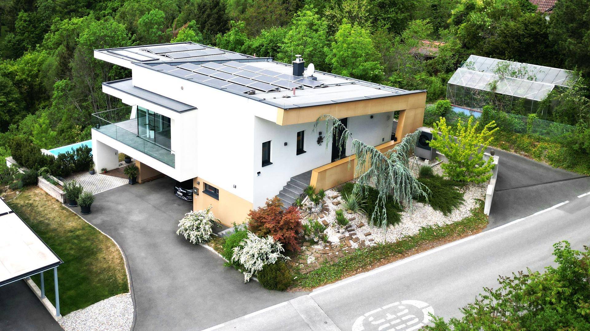 Moderne Villa mit Flachdach, Photovoltaikanlage und weitläufigem Grundstück.