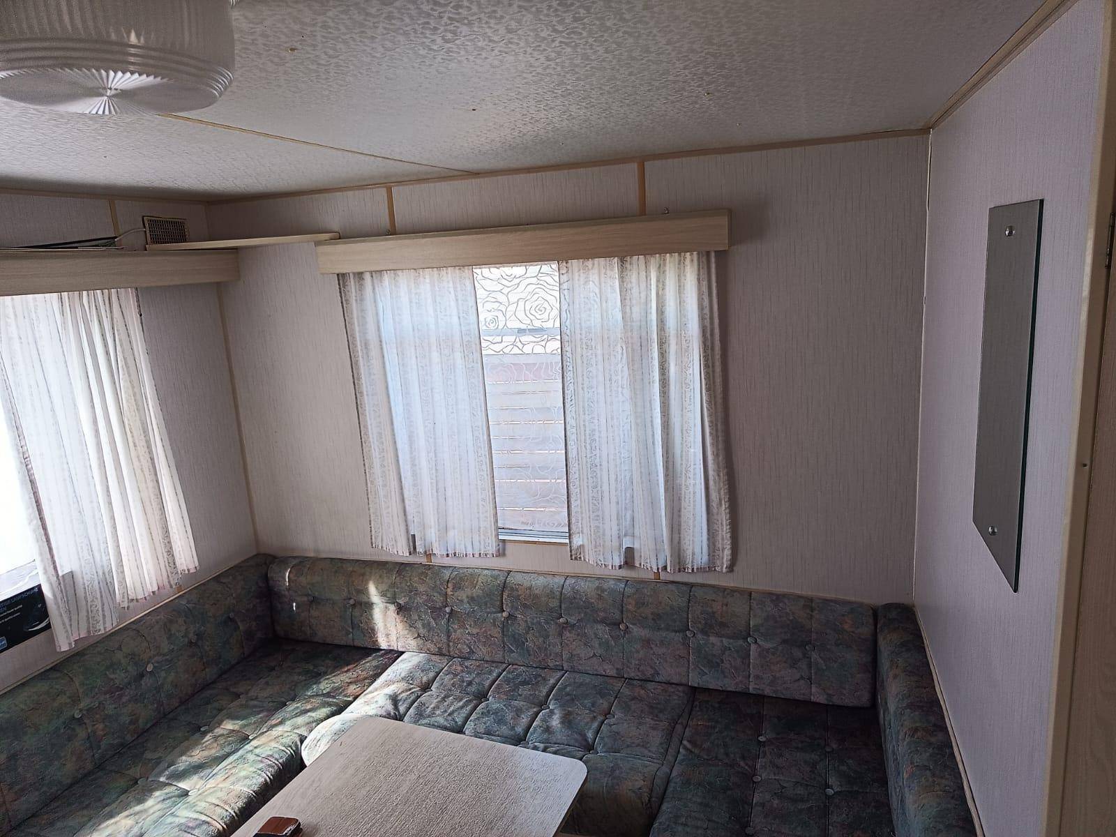 Gemütlicher Wohnbereich mit U-förmiger Sitzbank und kleinem Tisch, hell beleuchtet.