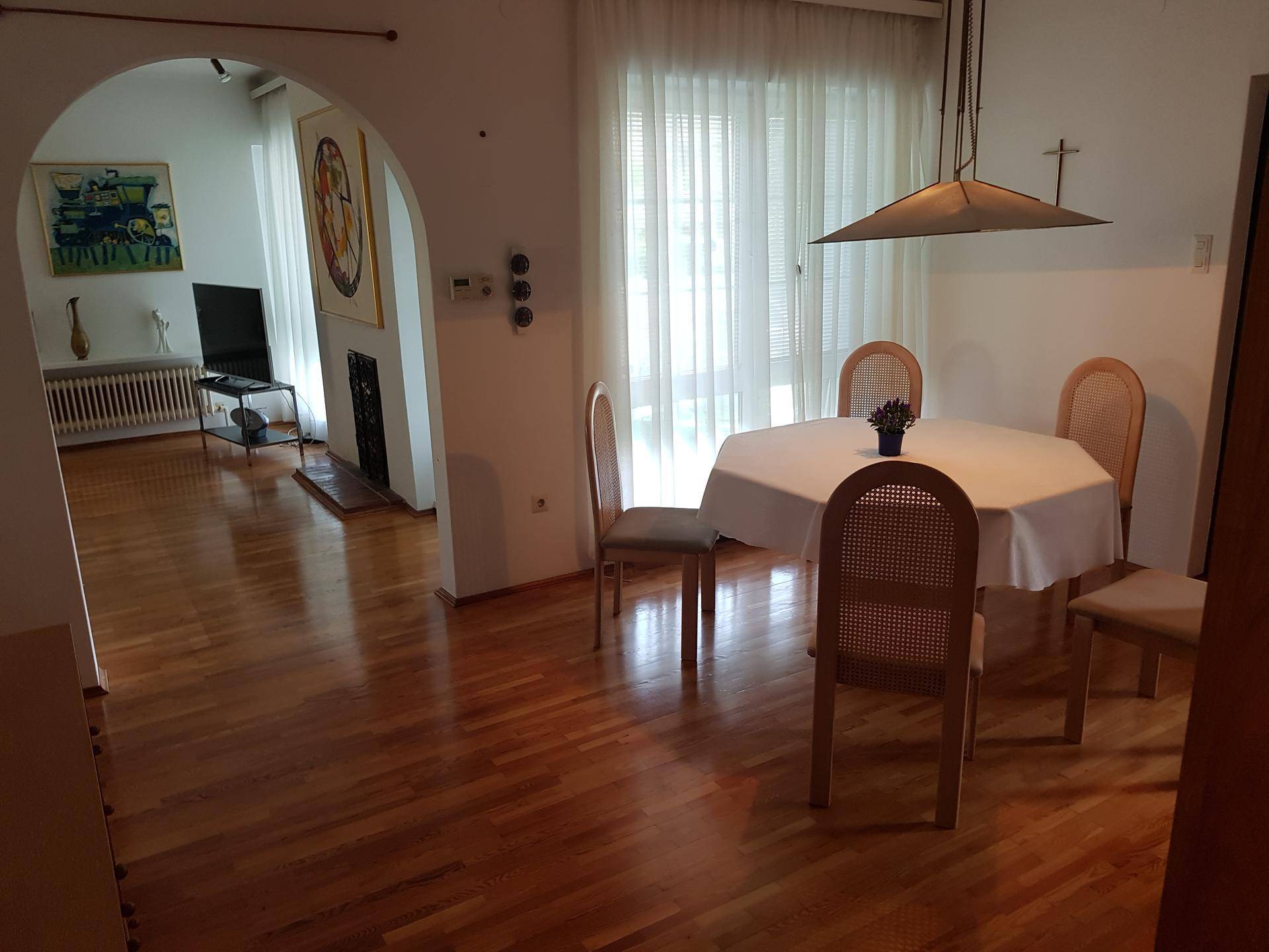 Heller Wohn-Essbereich mit Holzboden, Esstisch und Zugang zum Wohnzimmer.