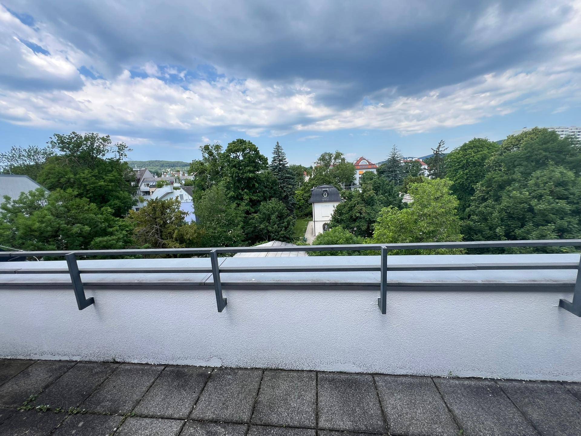 Große Dachterrasse mit weitem Blick über die grüne Umgebung und den blauen Himmel.