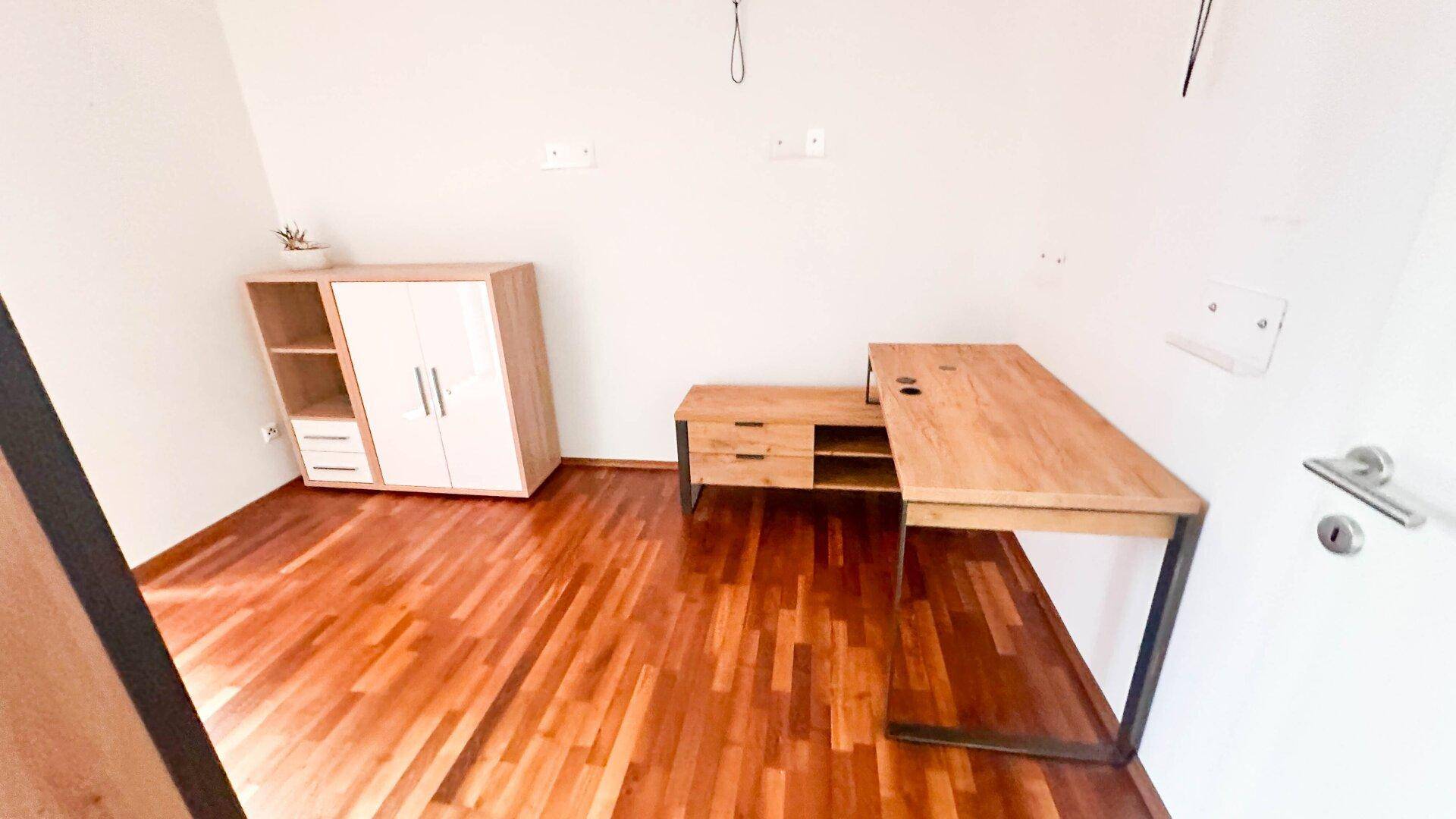 Geräumiges Arbeitszimmer mit Holzboden und modernem Schreibtisch, ideal für Home-Office.