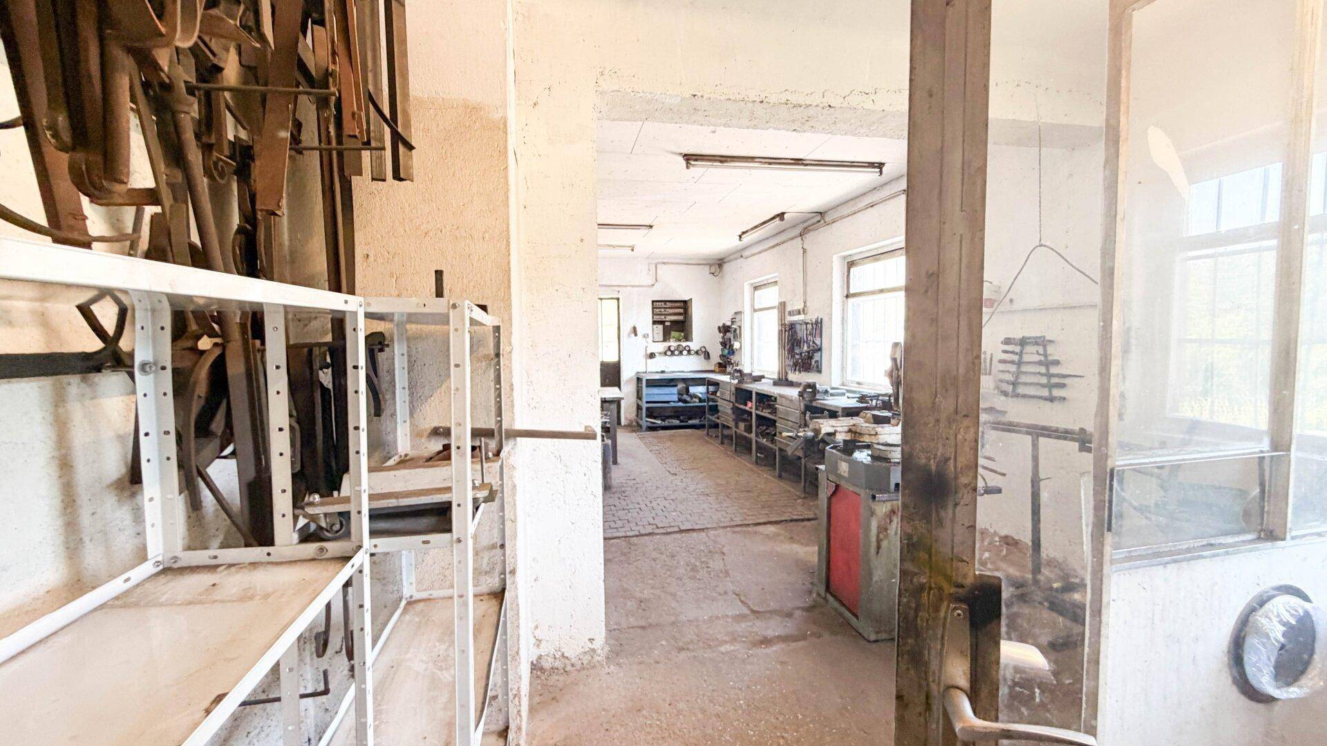 Blick durch die Werkstatt, der verschiedene Arbeitsbereiche und die offene Raumaufteilung zeigt.
