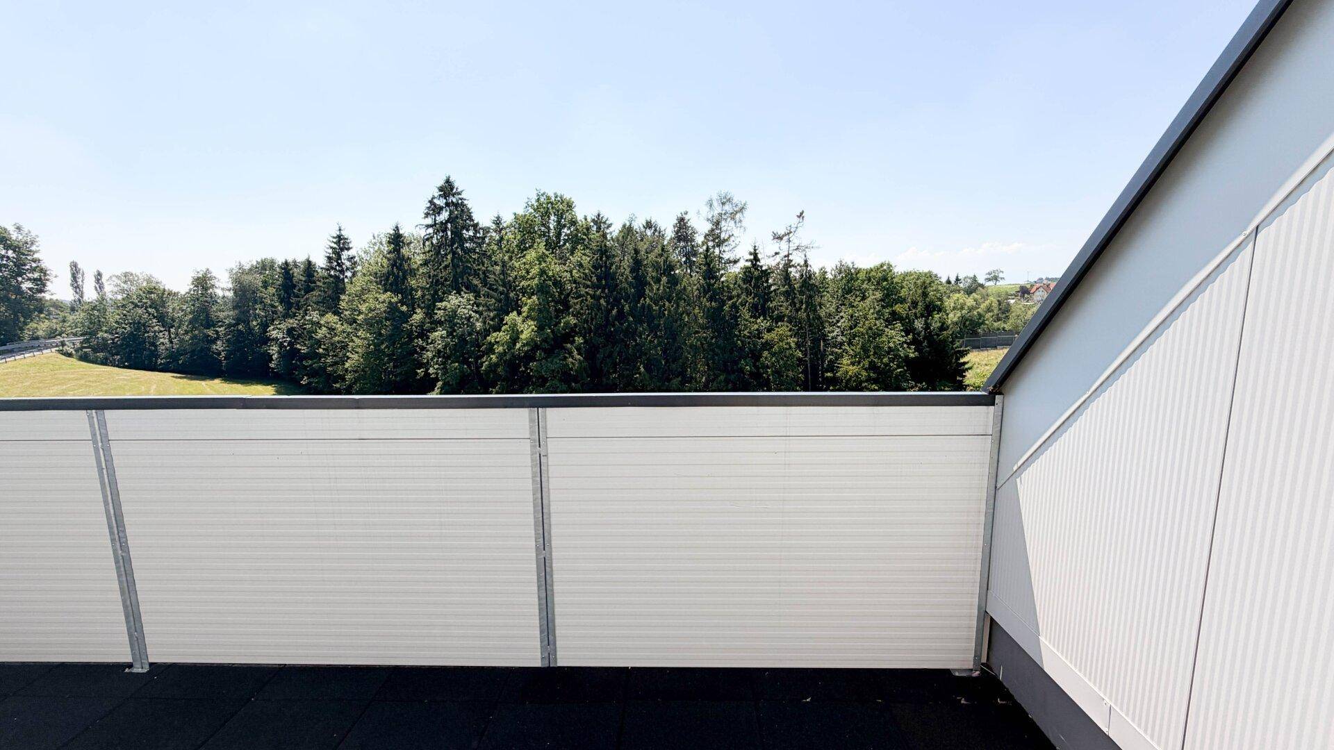 Balkon mit weitem Blick ins Grüne und auf die umliegende Naturlandschaft.