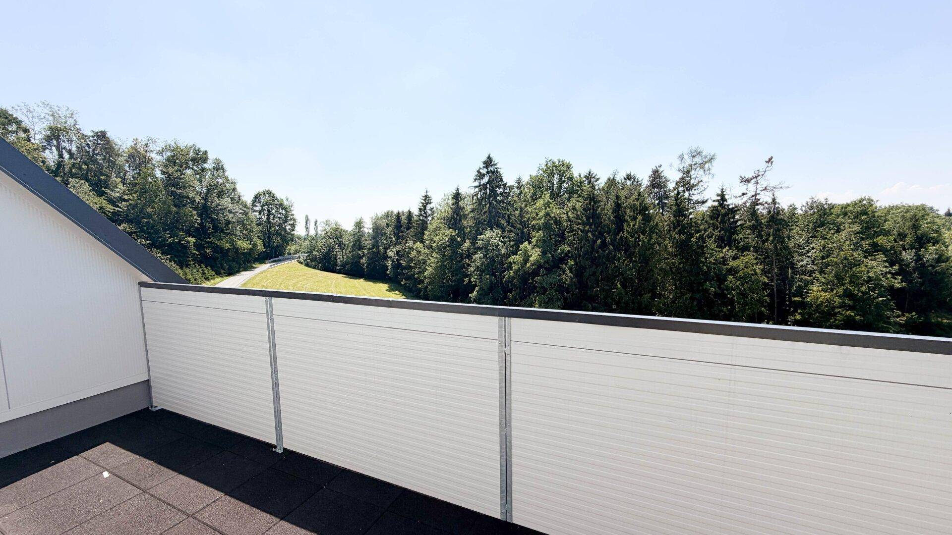 Geräumiger Balkon mit Blick ins Grüne und auf die umliegende Naturlandschaft.
