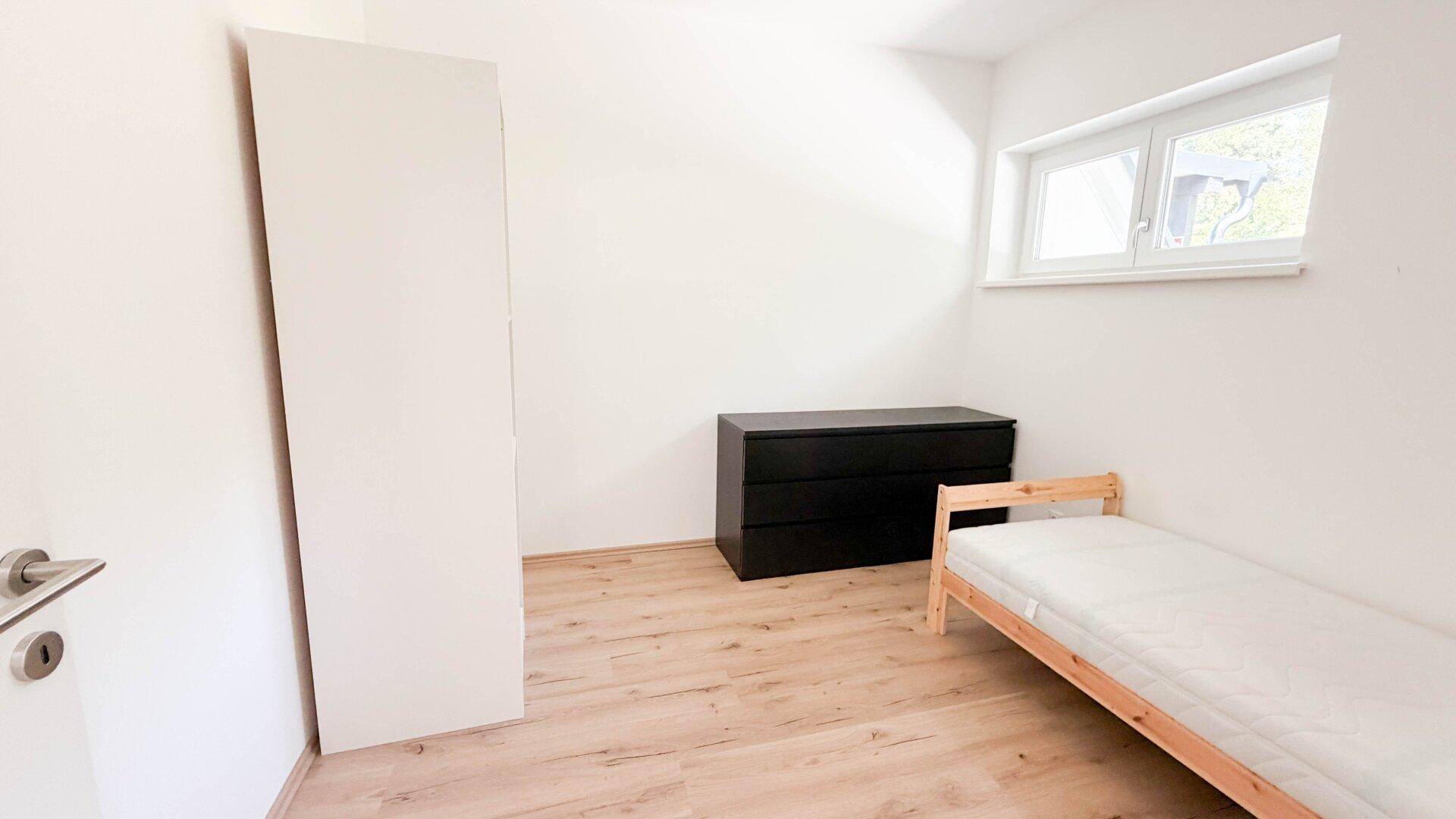 Kleines Schlafzimmer oder Kinderzimmer mit Einzelbett und Fenster.