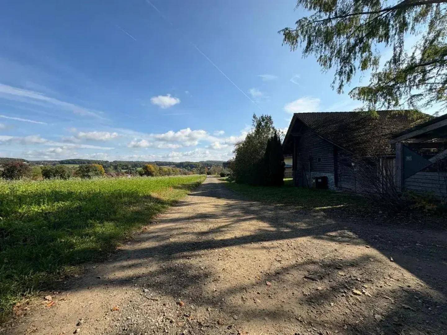 Ländlicher Feldweg neben dem Anwesen mit weitem Blick über die hügelige Landschaft.