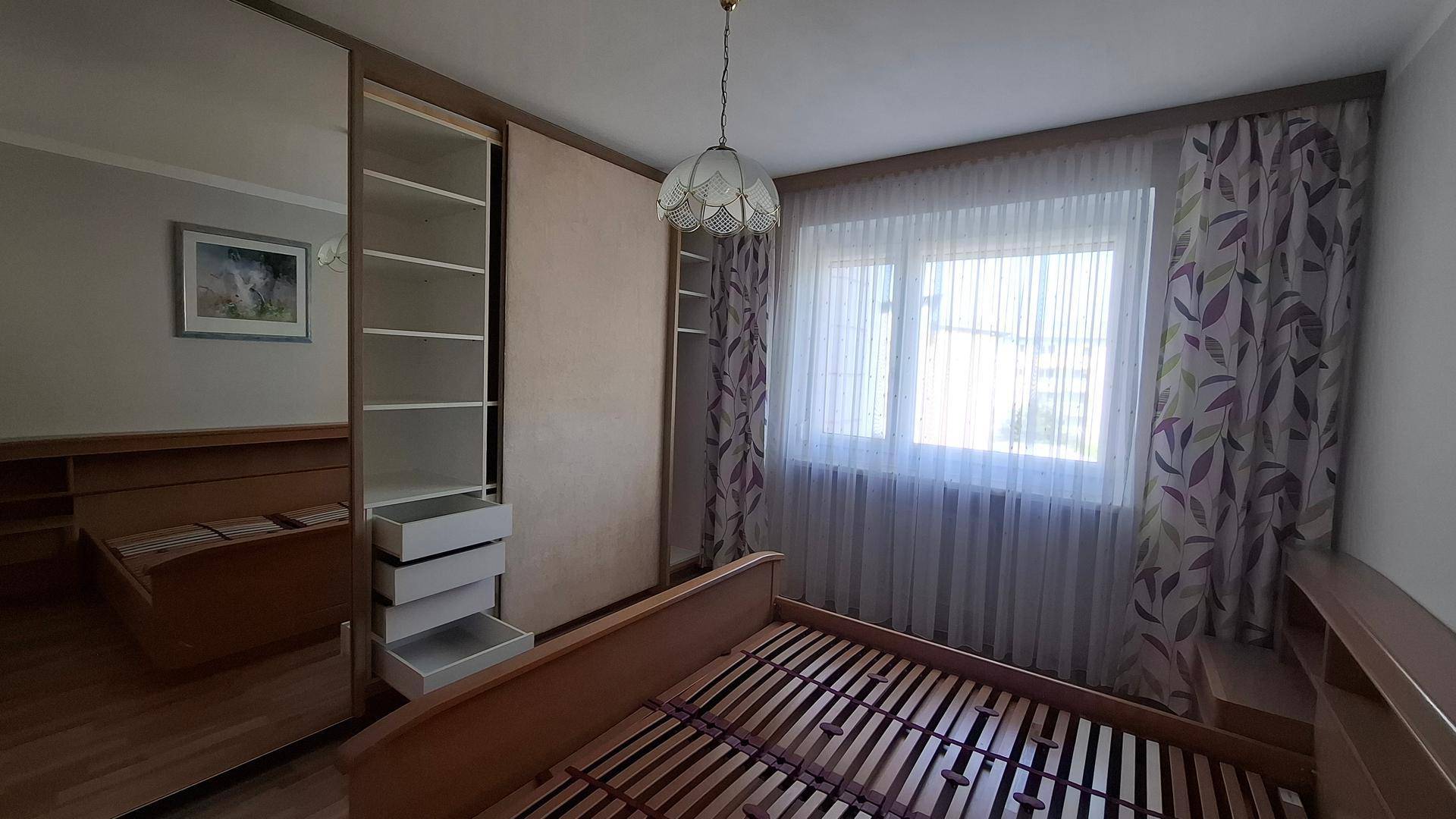 Schlafzimmer mit Einbauschränken und Holzbett, das eine praktische und wohnliche Atmosphäre schafft.