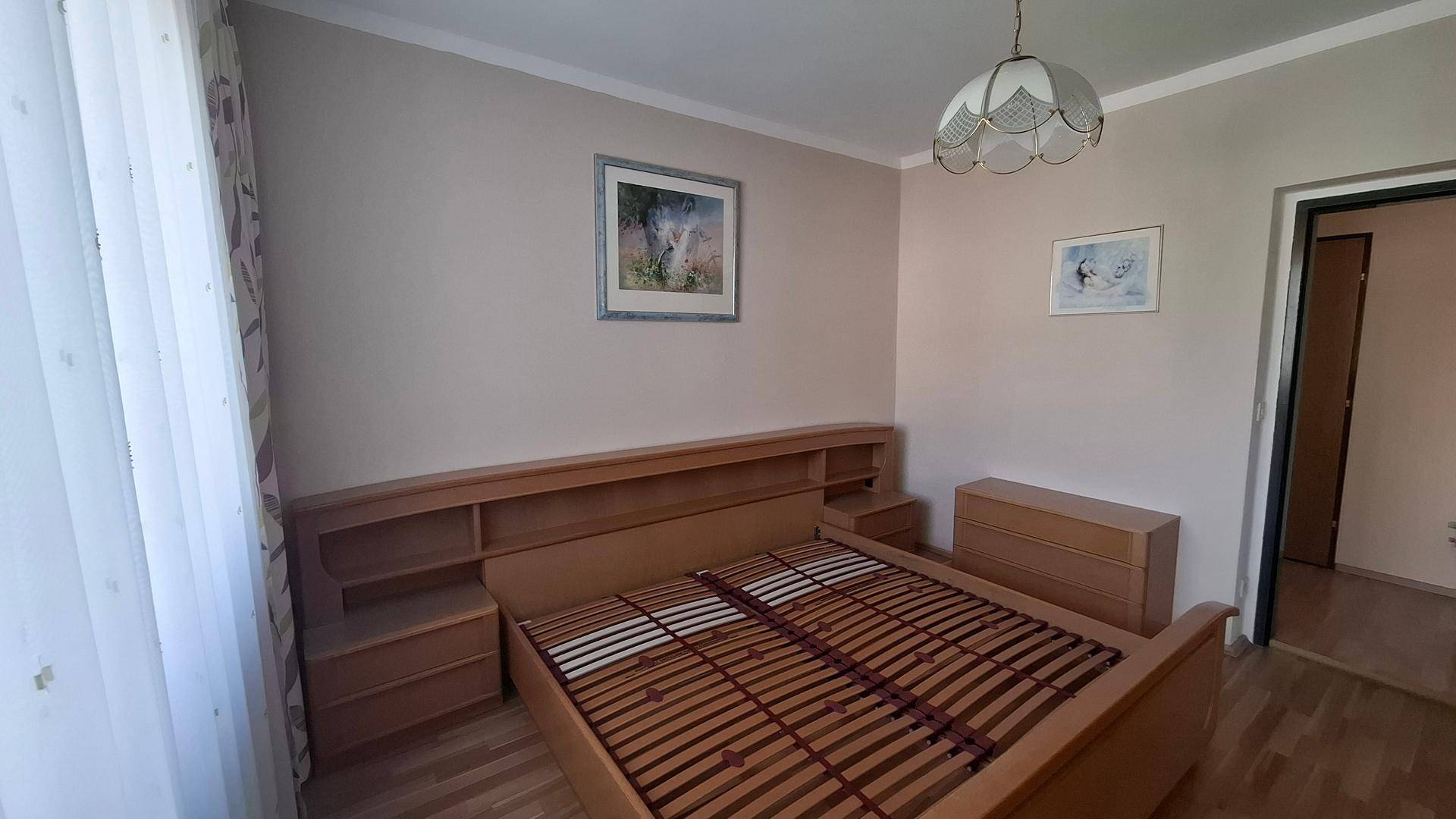 Gemütliches Schlafzimmer mit Holzbett und Nachttischen, bereit für persönliche Einrichtung.