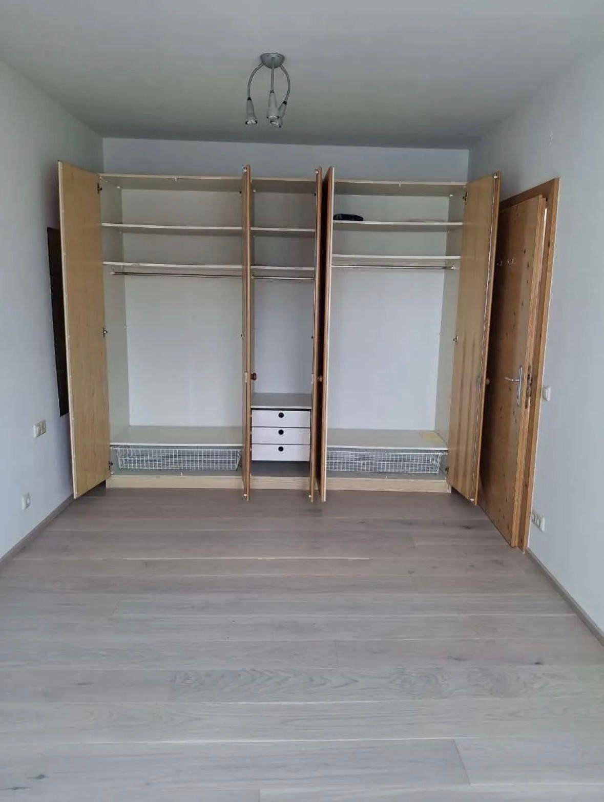 Schlafzimmer mit hellem Boden und praktischen Einbauschränken für ausreichend Stauraum.