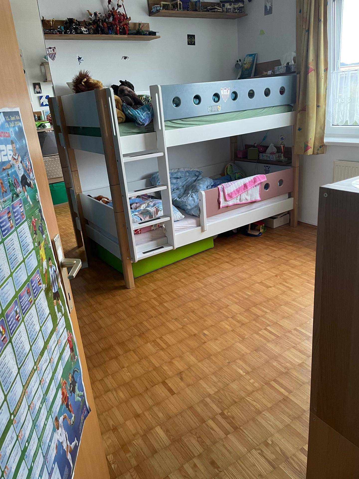 Kinderzimmer mit Etagenbett, Parkettboden und einem Fenster, ideal für Geschwister oder Übernachtungsgäste.