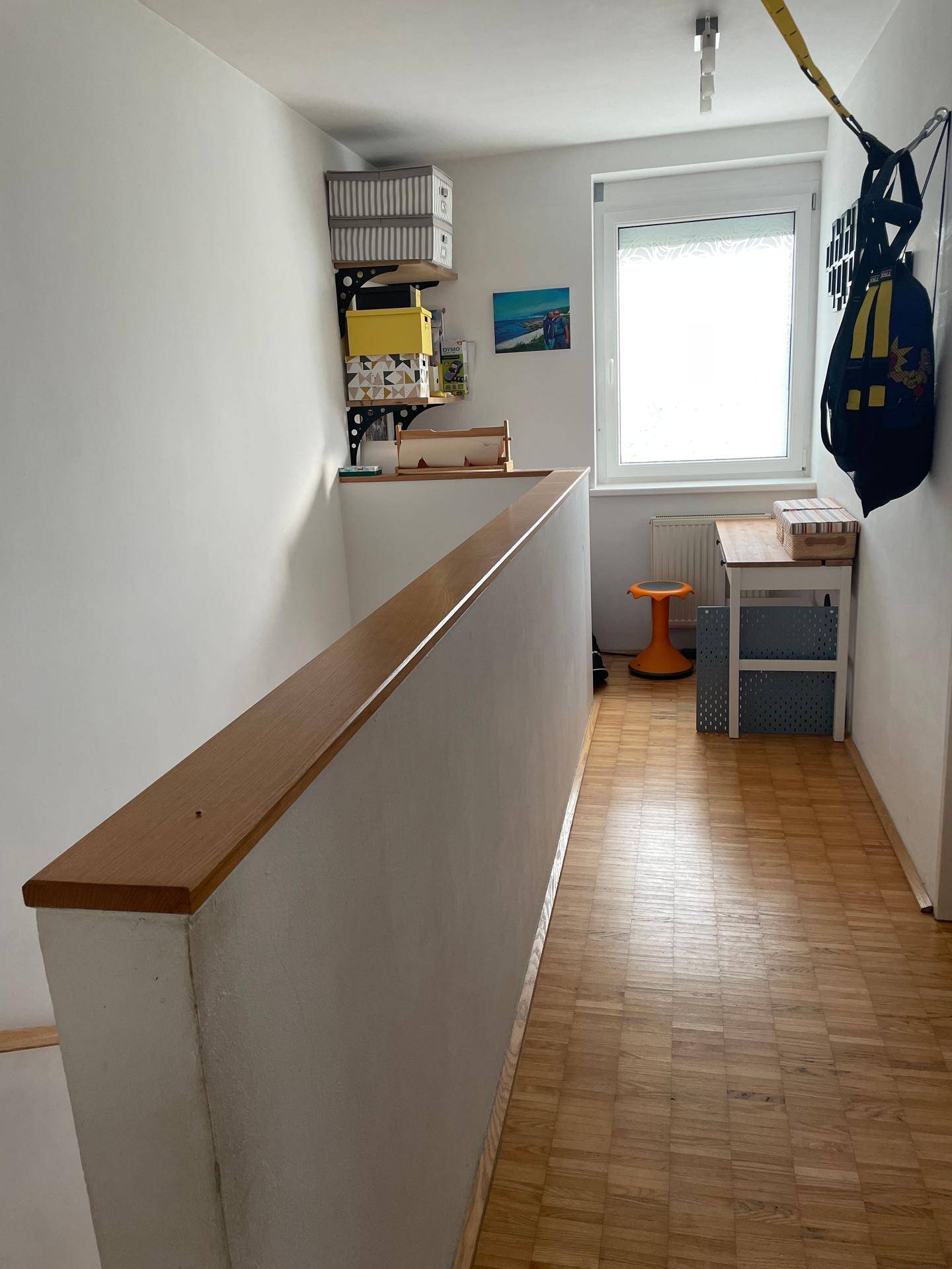 Heller Flur mit Parkettboden, einem Fenster und praktischen Regalen für zusätzlichen Stauraum.