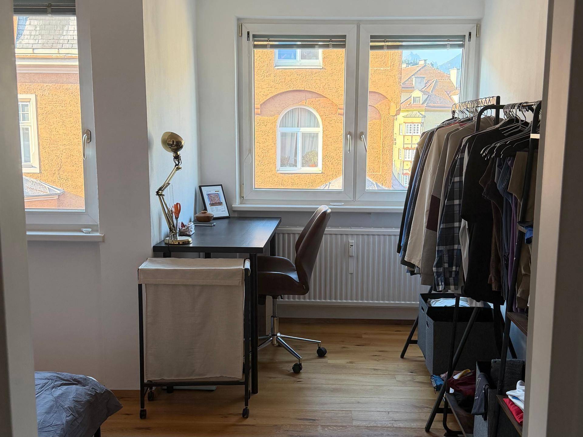 Heller Arbeitsbereich im Schlafzimmer mit Schreibtisch und Blick auf die umliegenden Gebäude.