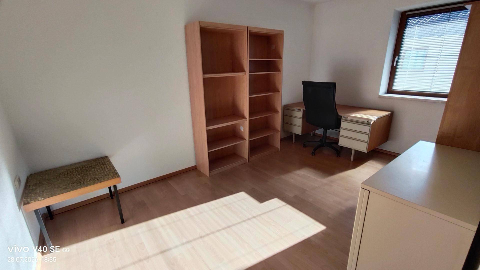 Funktionales Arbeitszimmer mit Schreibtisch, Bürostuhl und Bücherregalen, ideal für Home-Office.