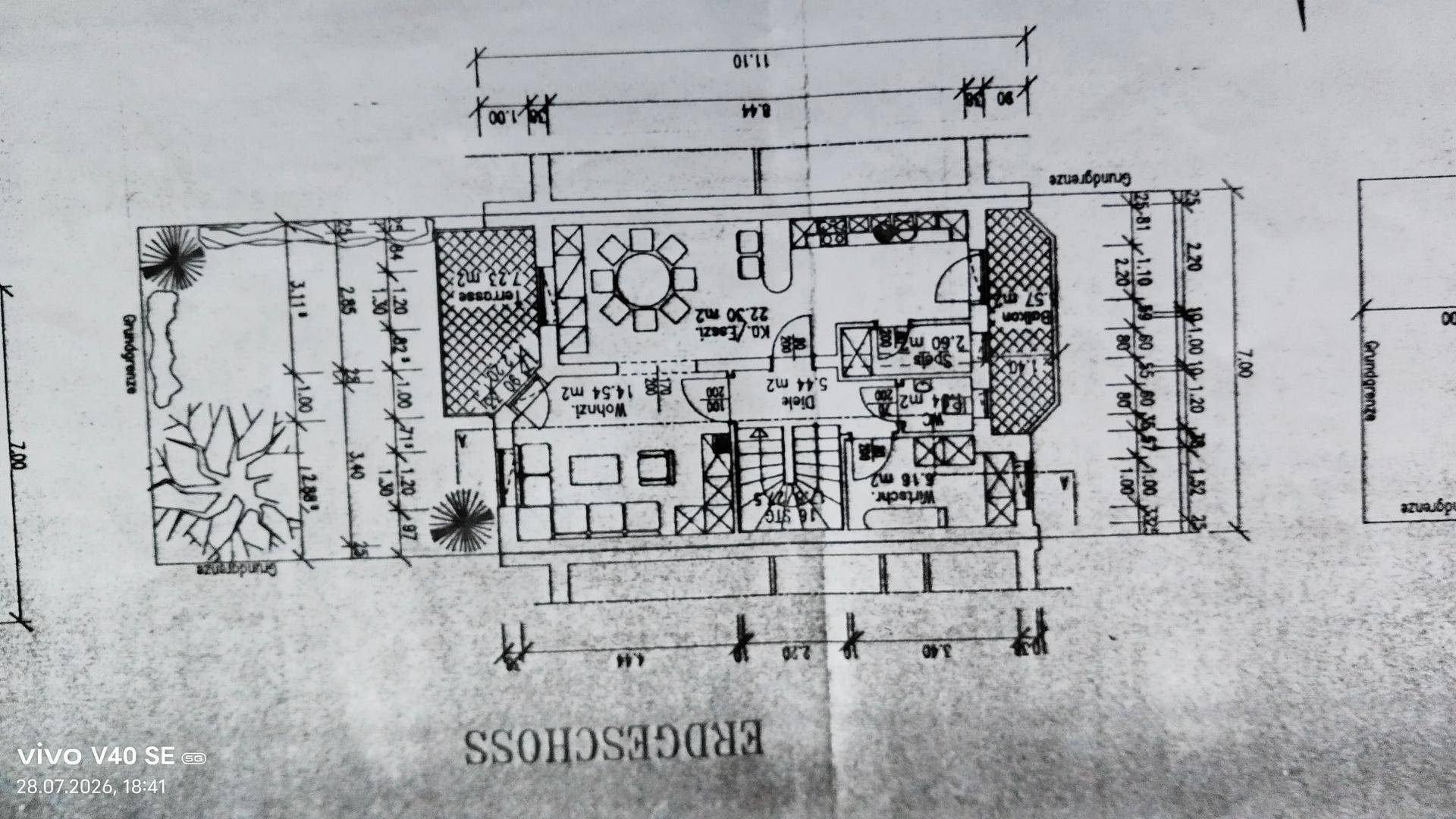 Grundriss des Erdgeschosses mit offenem Wohn-Essbereich, Küche, Terrasse und Garten.