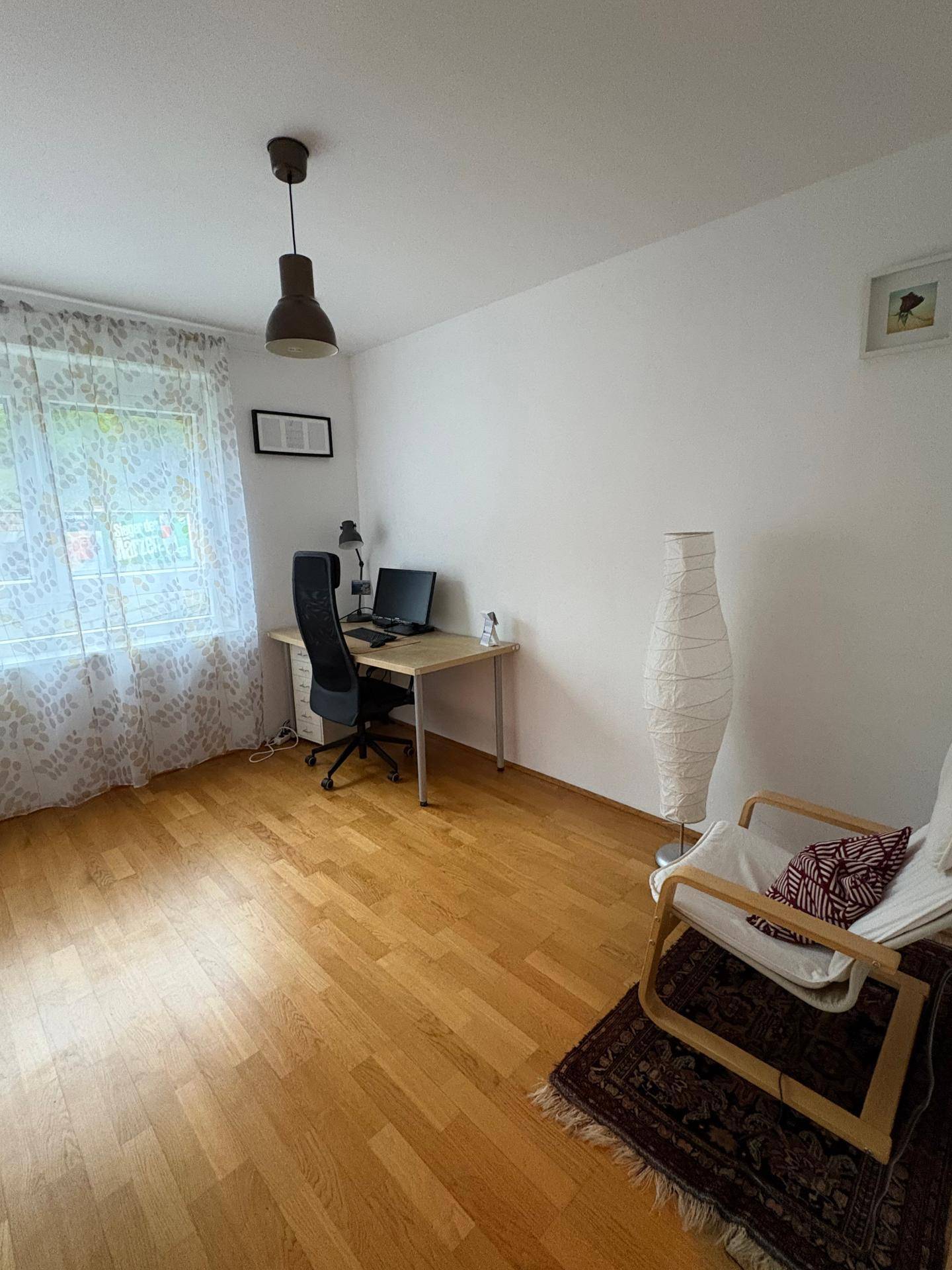 Helles Arbeitszimmer mit Schreibtisch, Bürostuhl und Parkettboden, ideal für Home-Office.