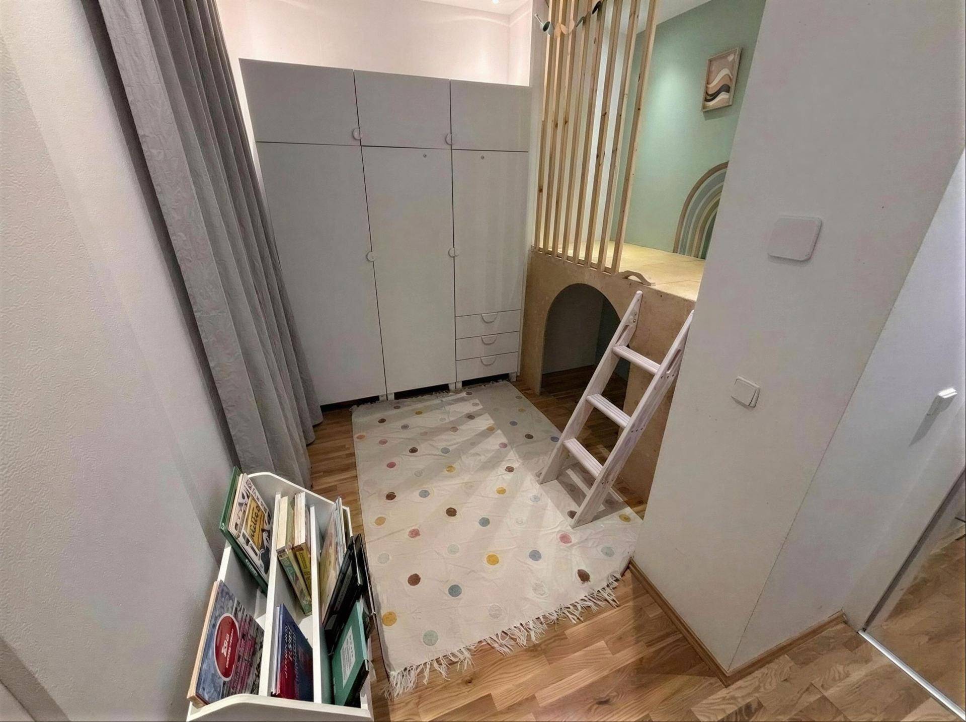 Kinderzimmer mit Hochbett, Kleiderschrank und Holzboden.