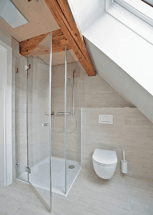 Helles Badezimmer im Dachgeschoss mit Dusche, wandhängendem WC und Dachfenster.