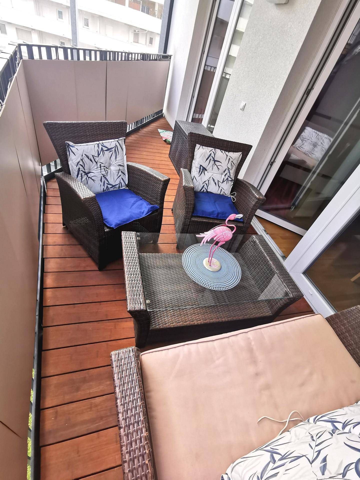 Attraktiver Balkon mit Holzdeck und bequemen Outdoor-Möbeln, perfekt für Entspannung im Freien.
