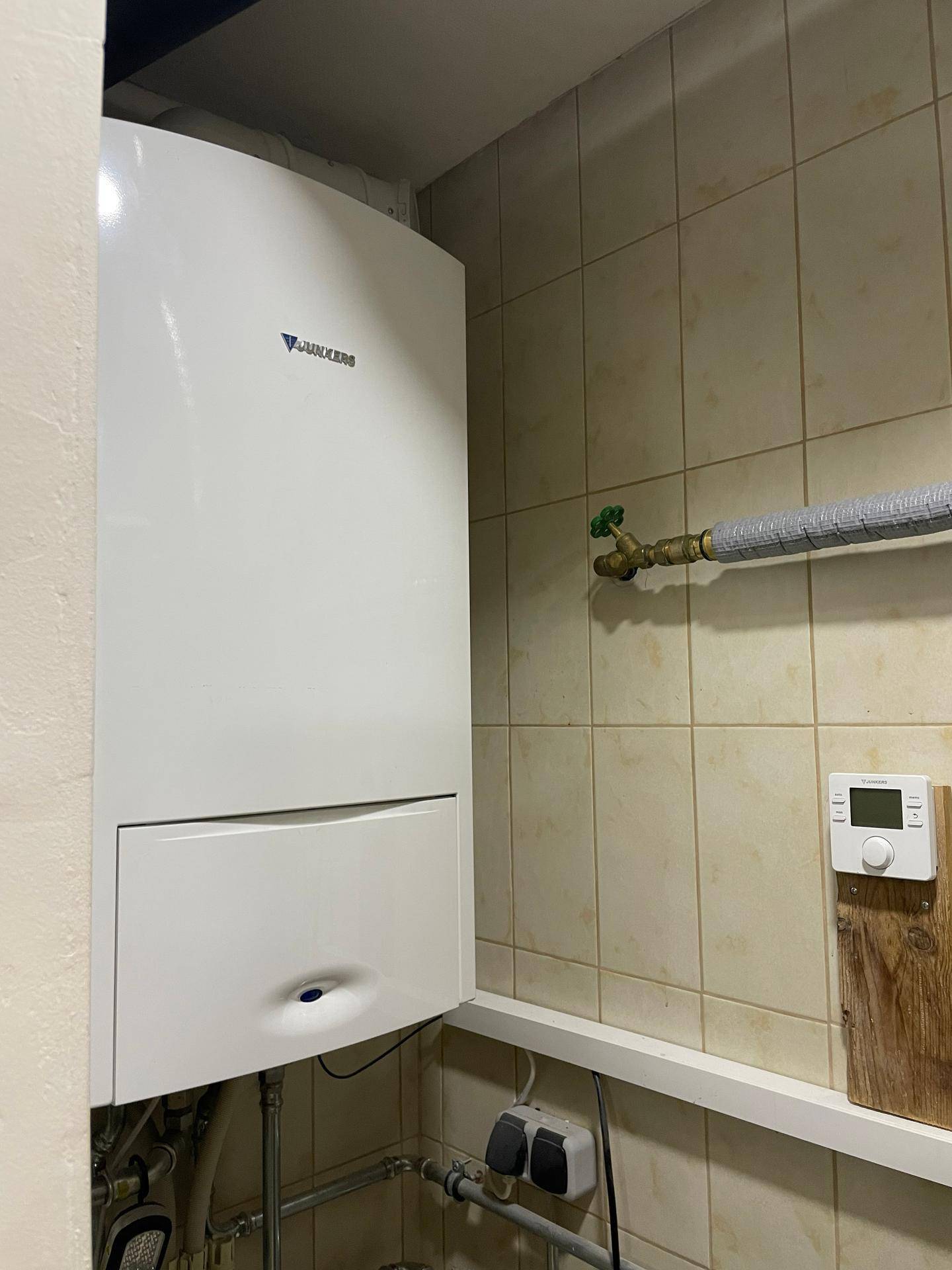 Hauswirtschaftsraum mit Gastherme und beigefarbenen Fliesen, dient als Technikraum des Hauses.
