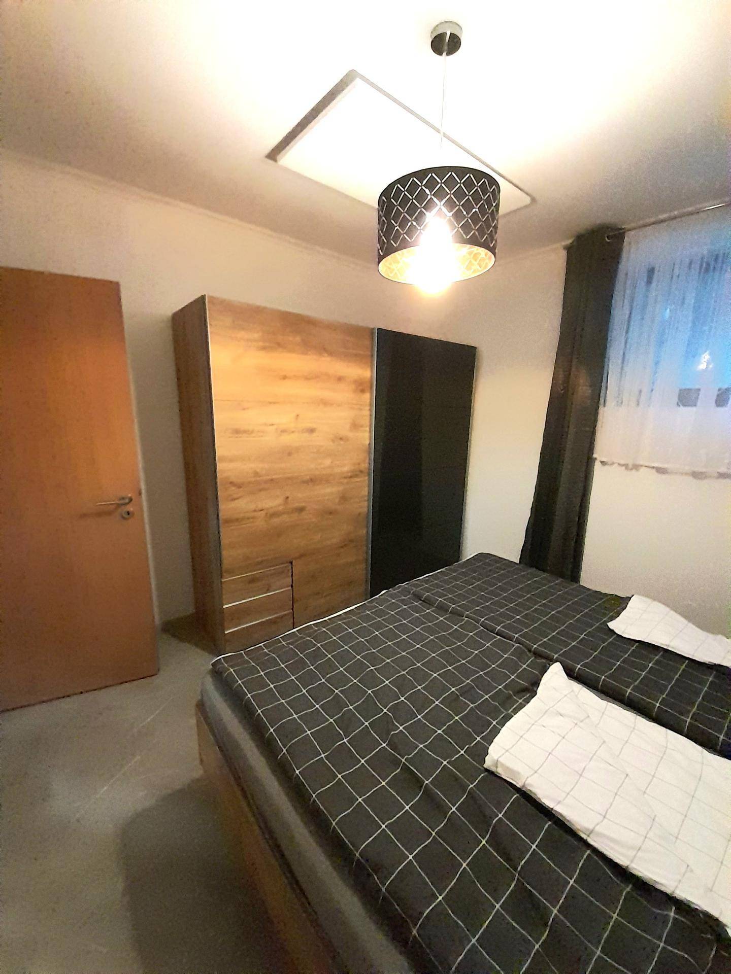 Schlafzimmer mit großem Kleiderschrank und bequemen Doppelbett.