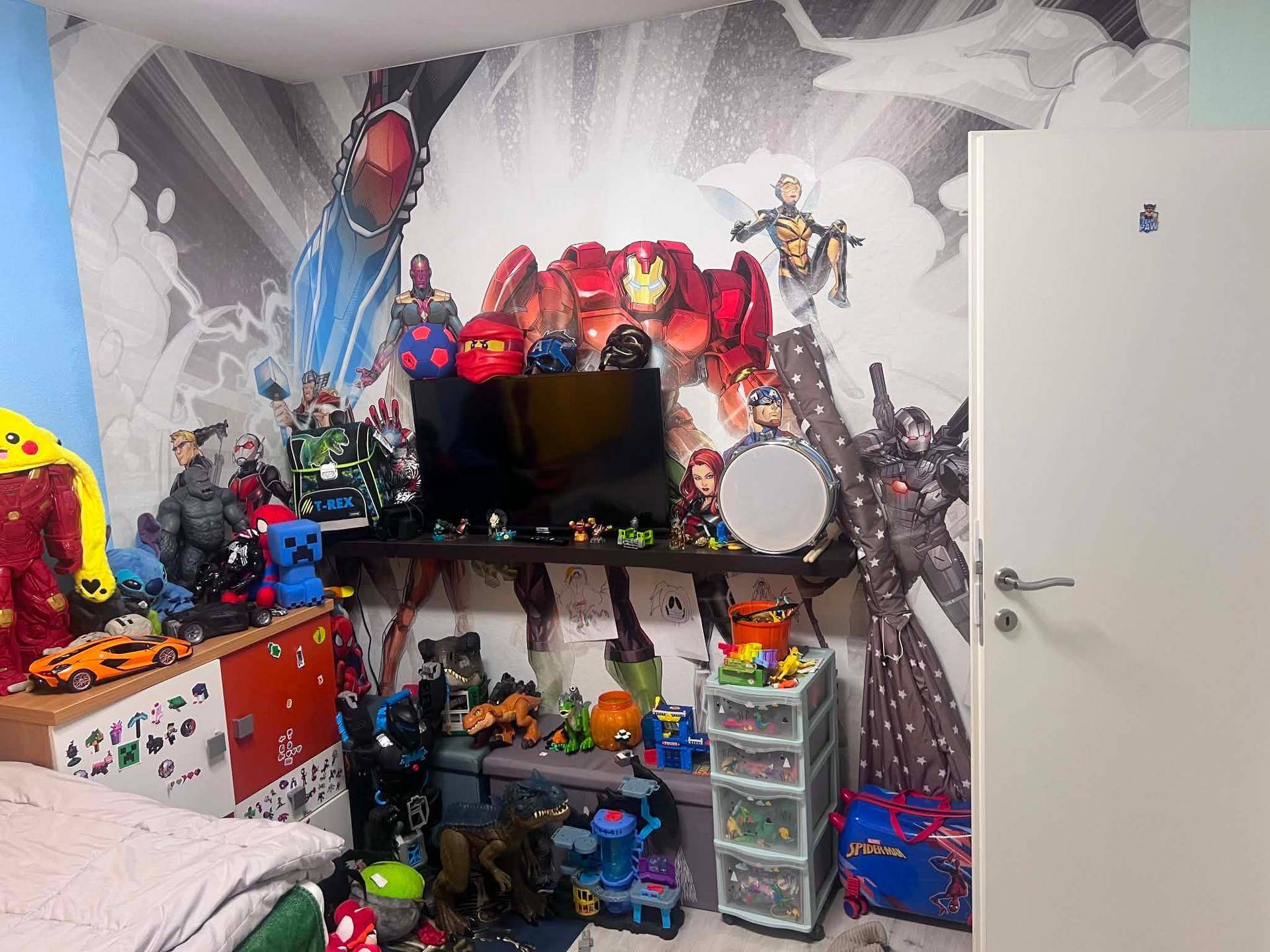 Kinderzimmer mit farbenfroher Superhelden-Wandmalerei und vielen Spielsachen.