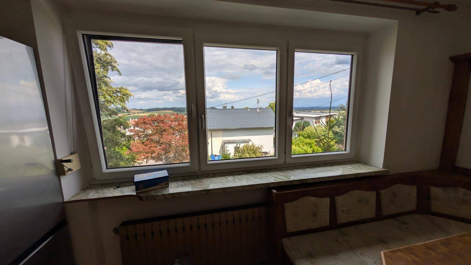 Fenster in der Küche mit weitem Blick über die umliegende Landschaft und Dächer.