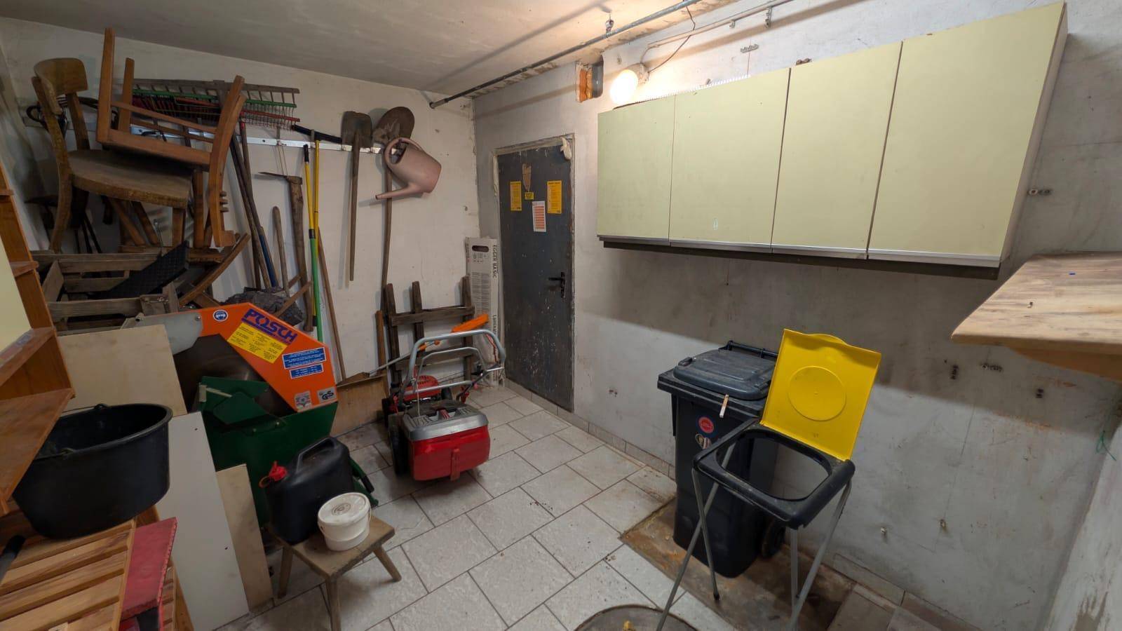 Geräumiger Abstellraum im Keller mit Regalen und verschiedenen Werkzeugen.