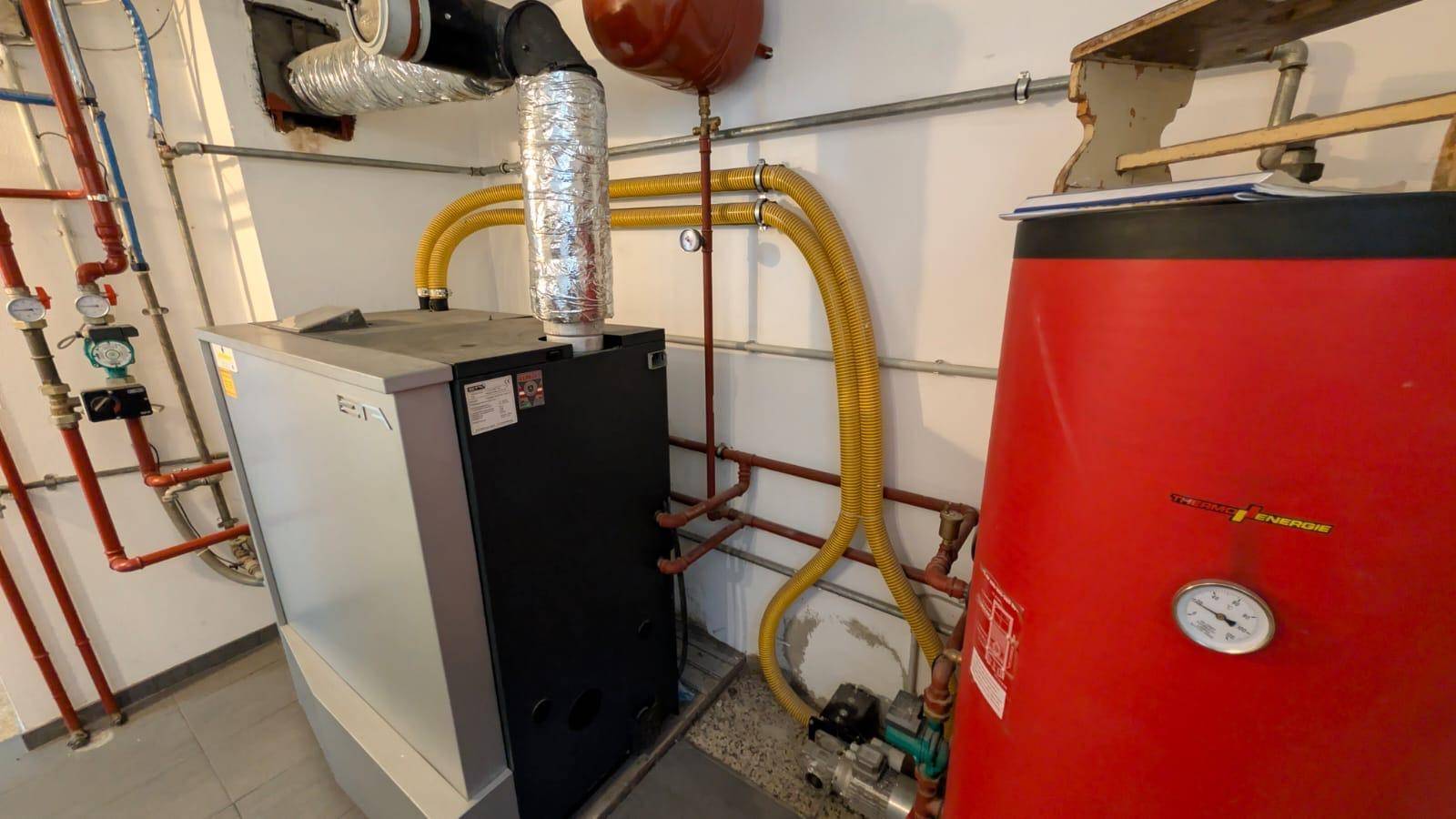 Heizungsraum mit moderner Heizungsanlage und Warmwasserspeicher.
