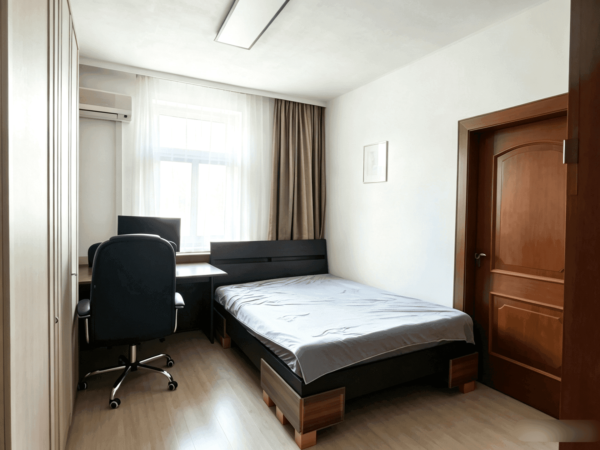 Kompaktes Schlafzimmer mit Einzelbett, Schreibtisch, Kleiderschrank und Klimaanlage.