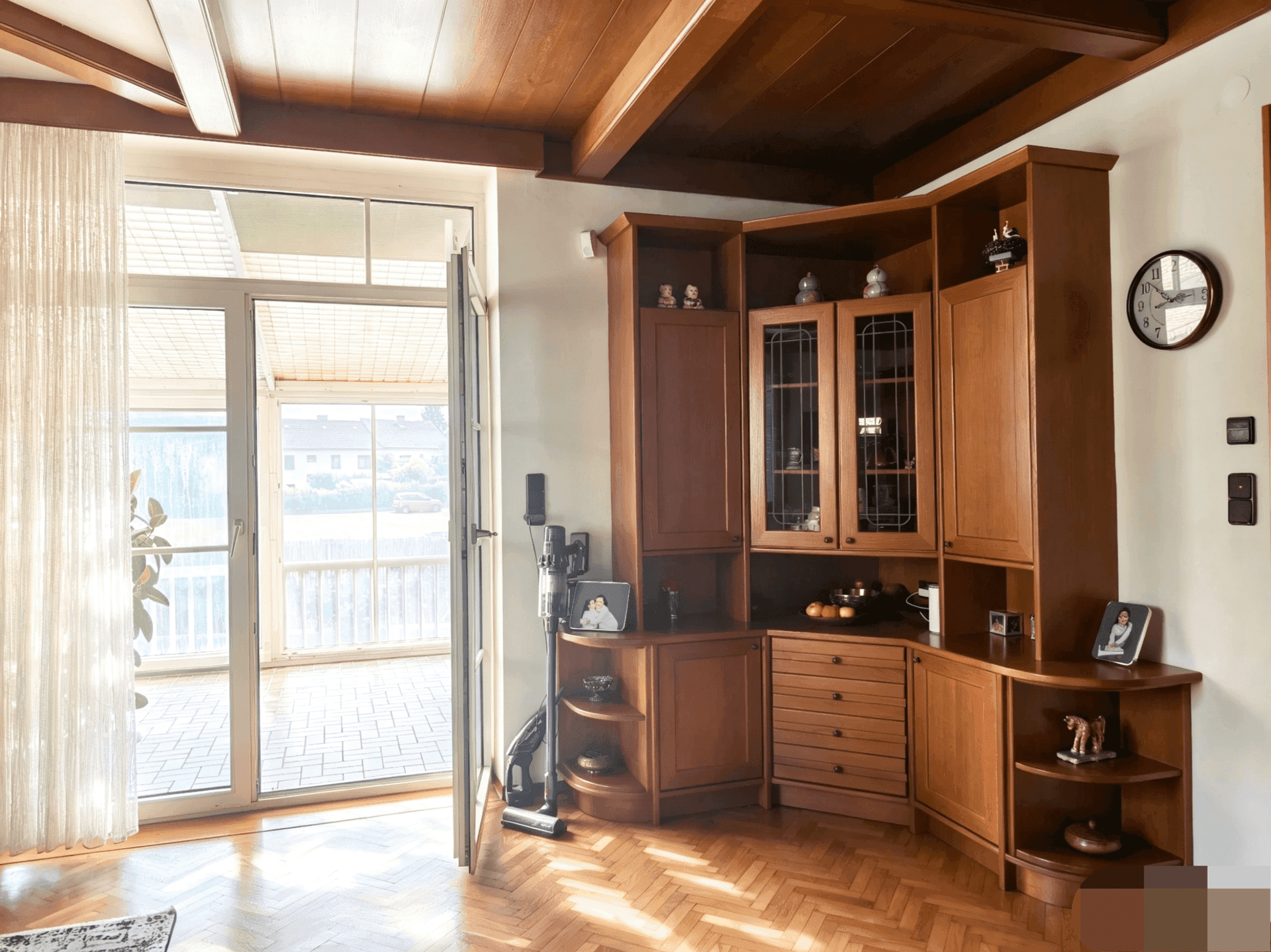 Eckschrank im Wohn-Essbereich mit Vitrinen und Zugang zum hellen Wintergarten.