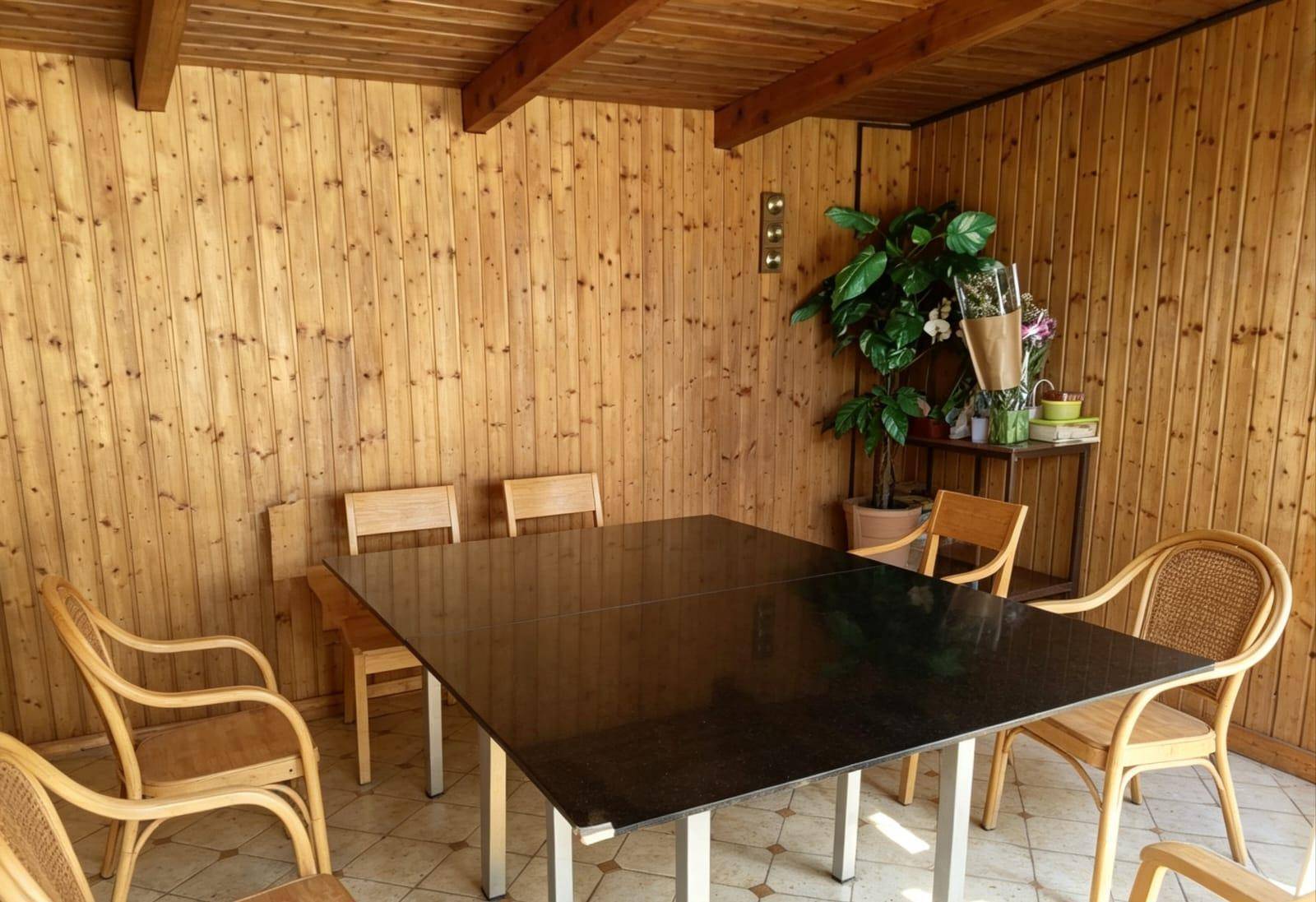 Rustikaler Essbereich in einem Holzpavillon mit Holzwänden und -decke.