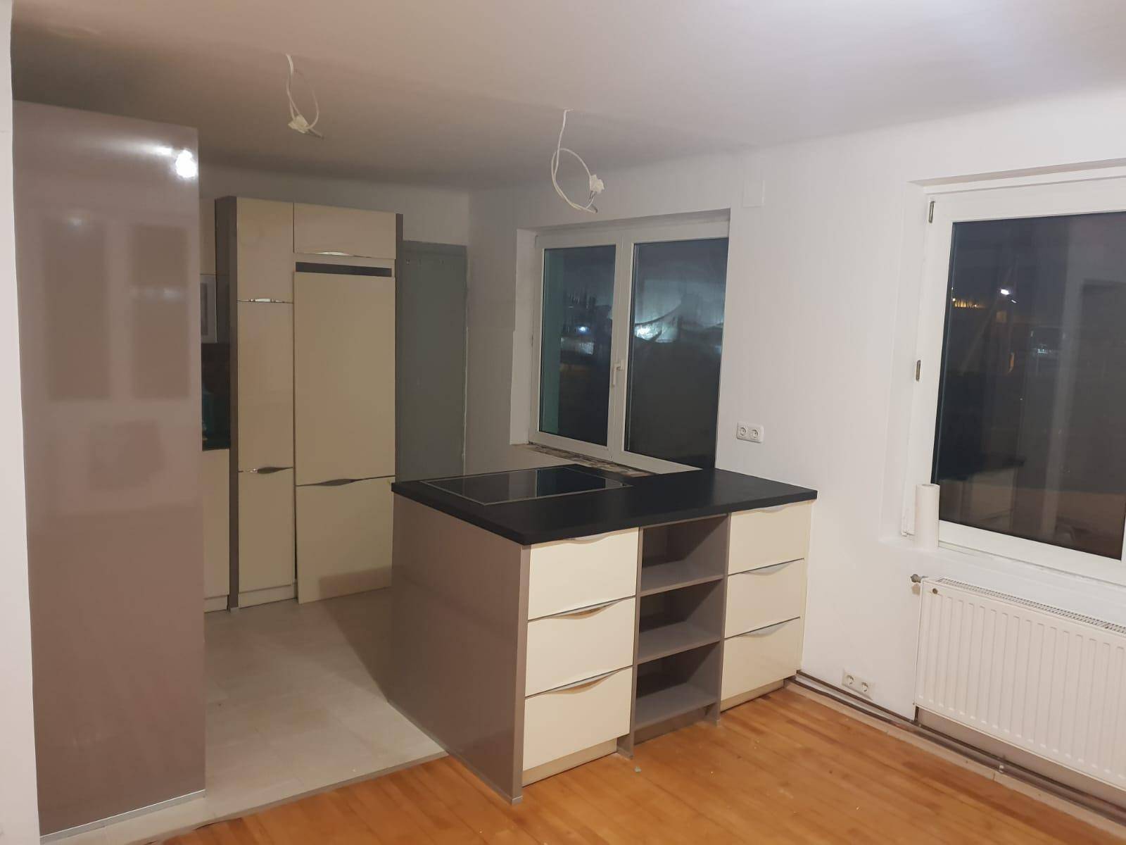 Küchenbereich mit Einbauküche und Kühlschrank, bereit für die Fertigstellung.