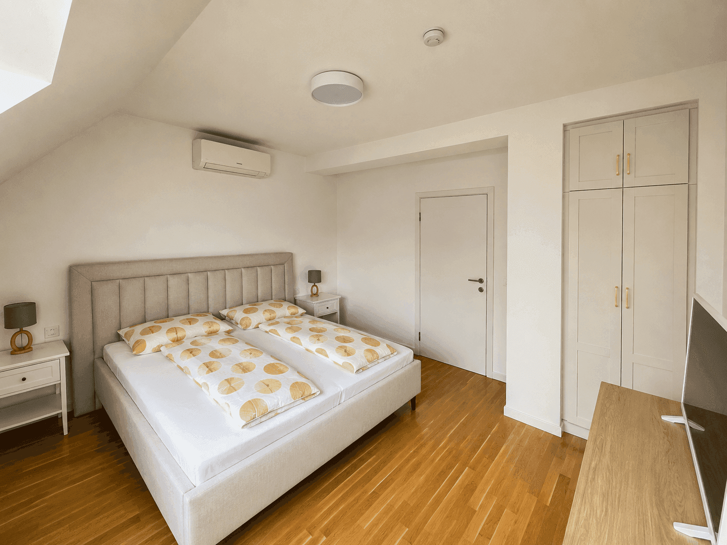 Gemütliches Schlafzimmer mit Doppelbett, Holzboden und Einbauschrank.
