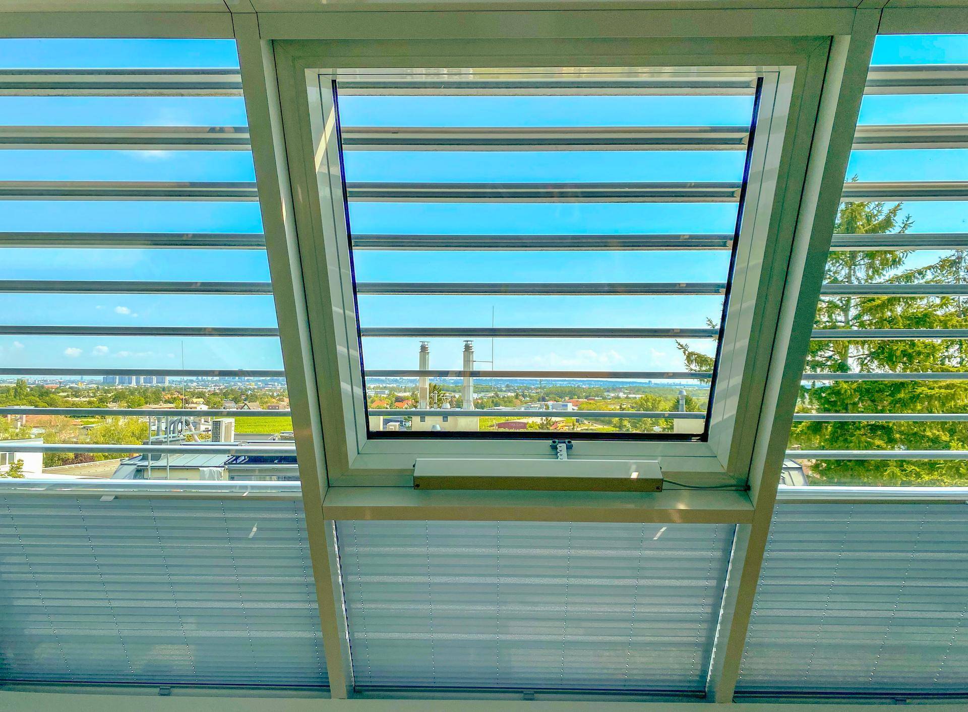 Dachfenster mit Jalousien bietet einen weiten Blick über die Landschaft.